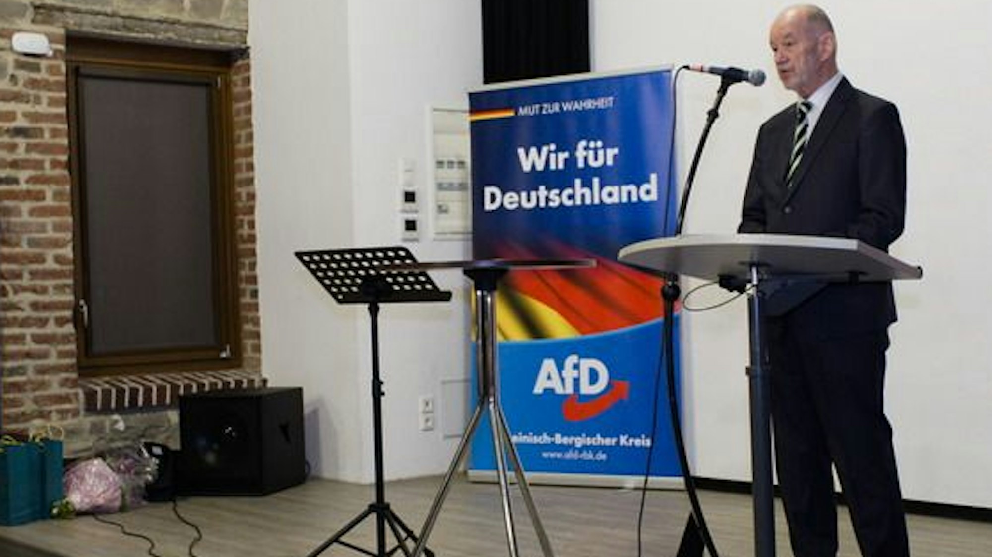 Dr. Helmut Waniczek, Sprecher des AfD-Kreisverbandes, steht am rednerpult im Overather Kulturbahnhof.