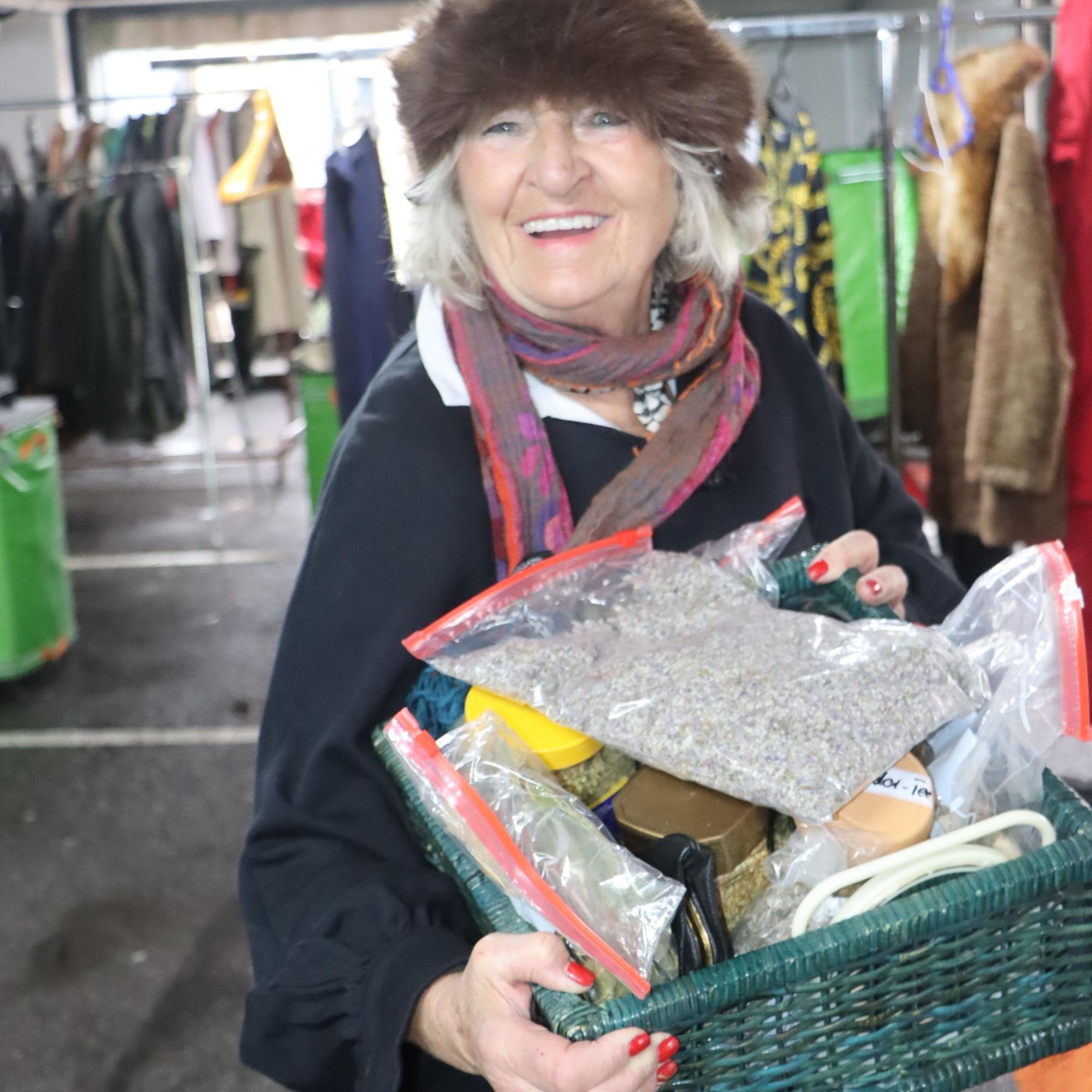 Zu sehen ist eine Frau, die einen Korb in den Händen hält.