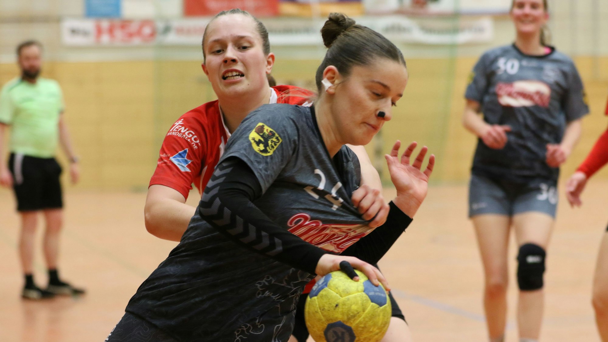 Die Abwehrspielerin hält Marei Nuss am Trikot fest.