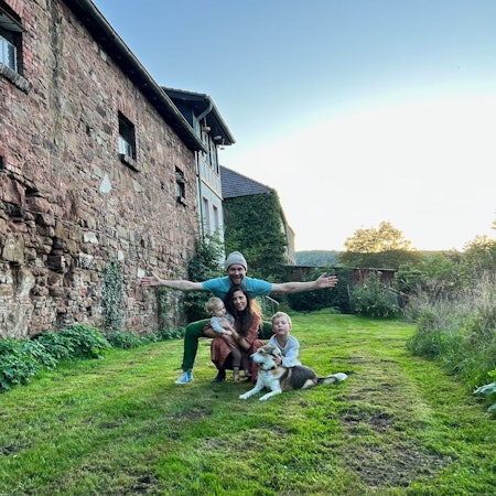 Die Familie und der Hund vor dem Außengemäuer der Burganlage.