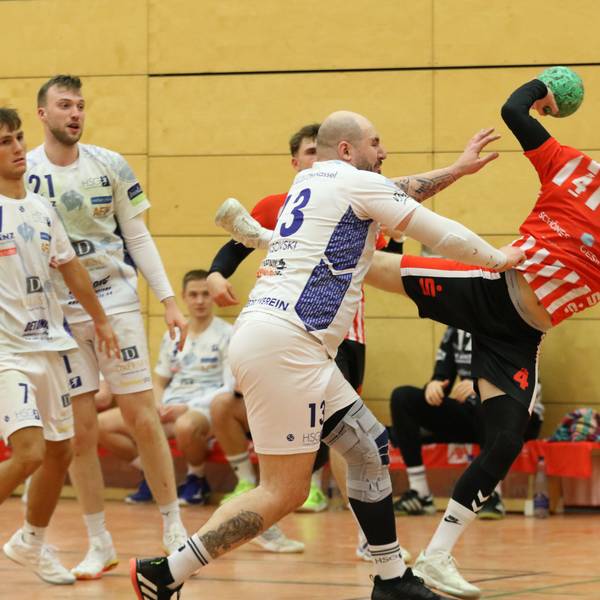 Merlin Klocker beim Wurf. Ein Gegenspieler greift mit dem rechten Arm nach dessen Trikot.