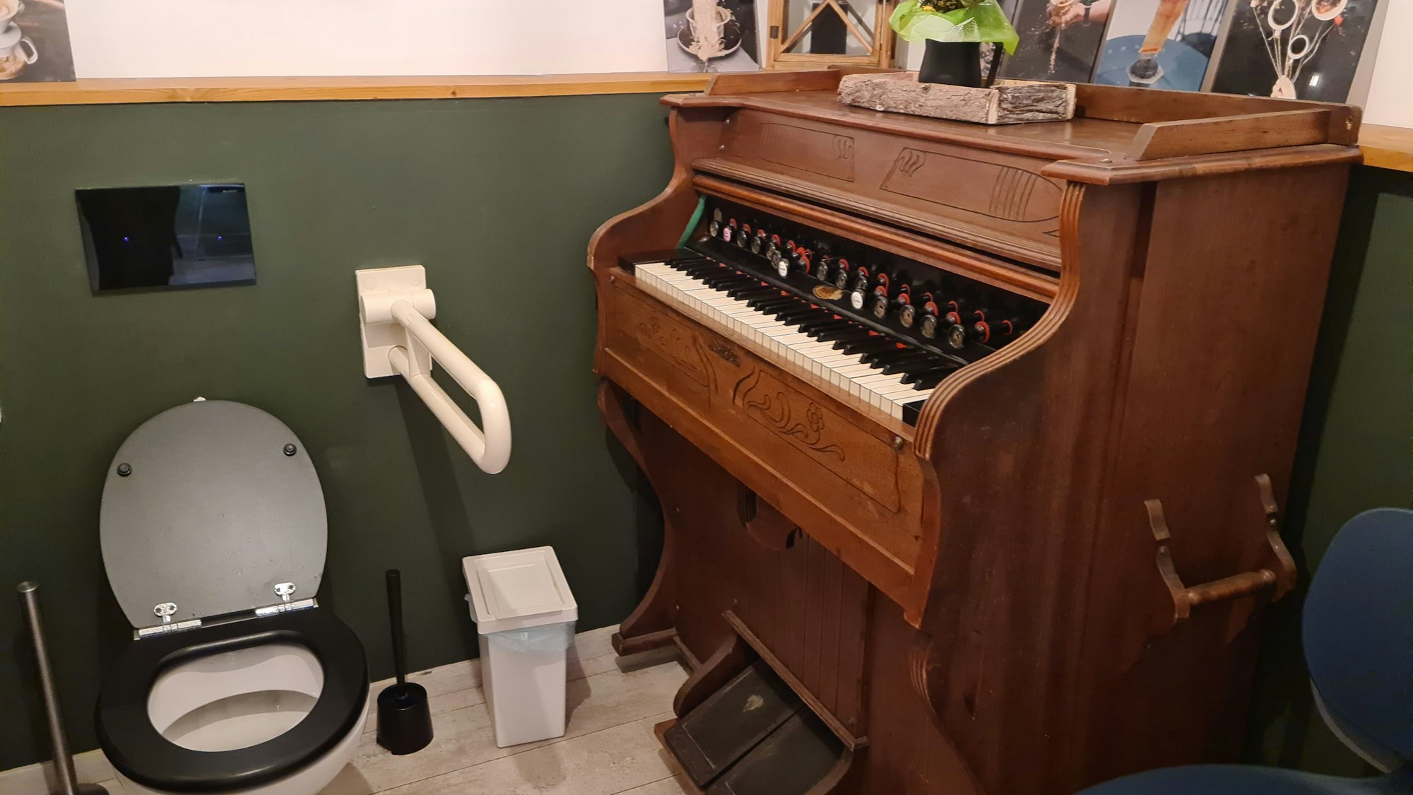 In einer Toilette steht eine Orgel neben dem Klo.