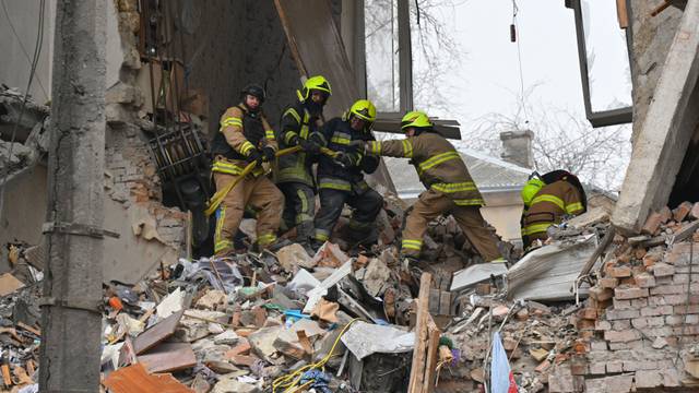 27.01.2026, Ukraine, Odessa: Rettungskräfte beseitigen die Trümmer eines Wohnhauses, das nach einem Raketeneinschlag in Odessa schwer beschädigt wurde.
