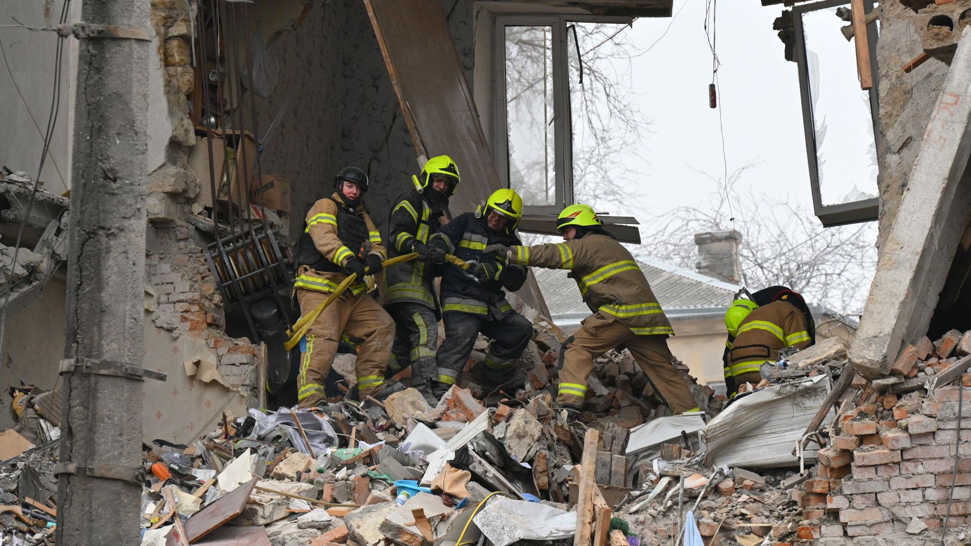 27.01.2026, Ukraine, Odessa: Rettungskräfte beseitigen die Trümmer eines Wohnhauses, das nach einem Raketeneinschlag in Odessa schwer beschädigt wurde.