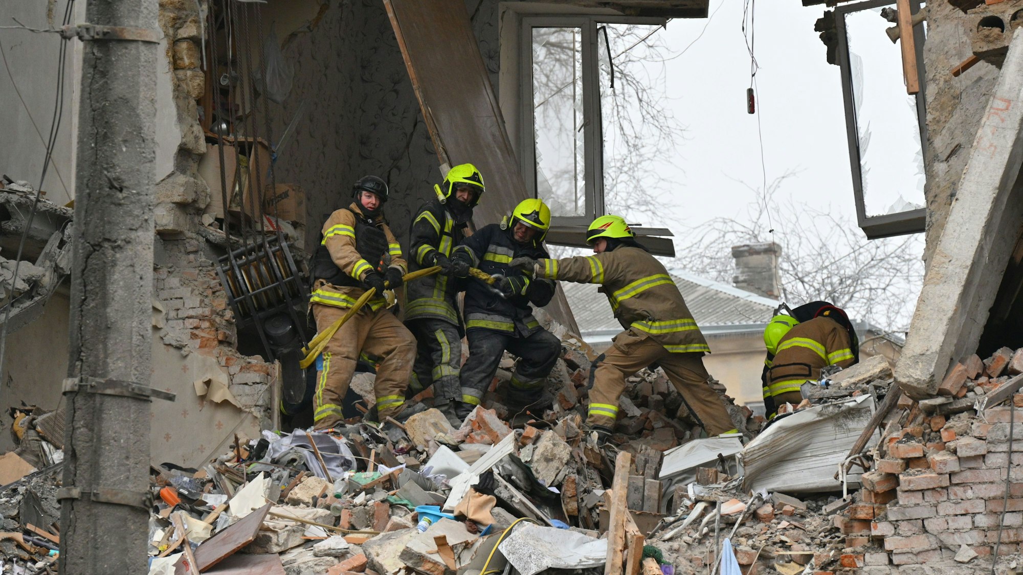 27.01.2026, Ukraine, Odessa: Rettungskräfte beseitigen die Trümmer eines Wohnhauses, das nach einem Raketeneinschlag in Odessa schwer beschädigt wurde.