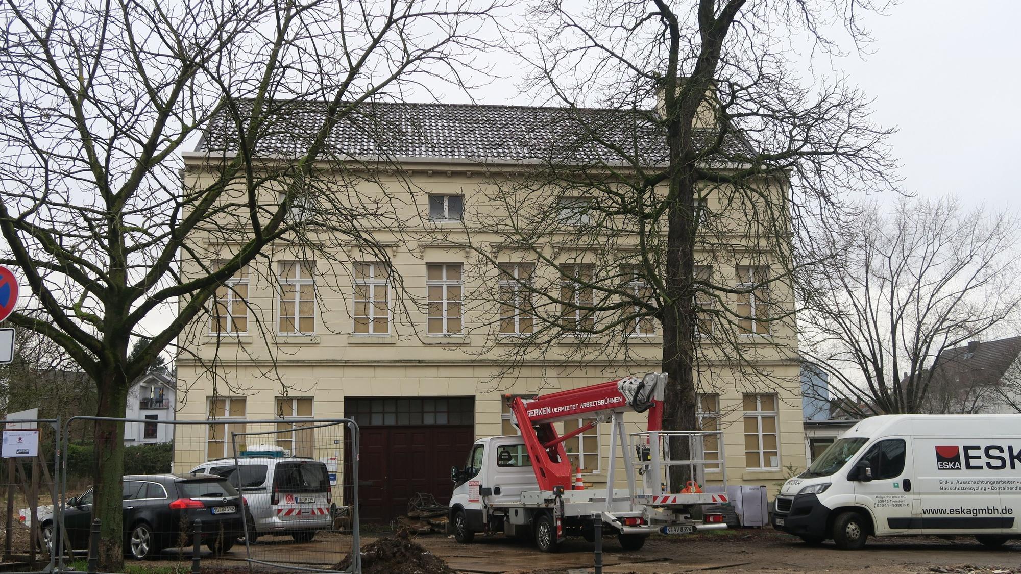 Ein altes Gebäude steht hinter einem Bauzaun.