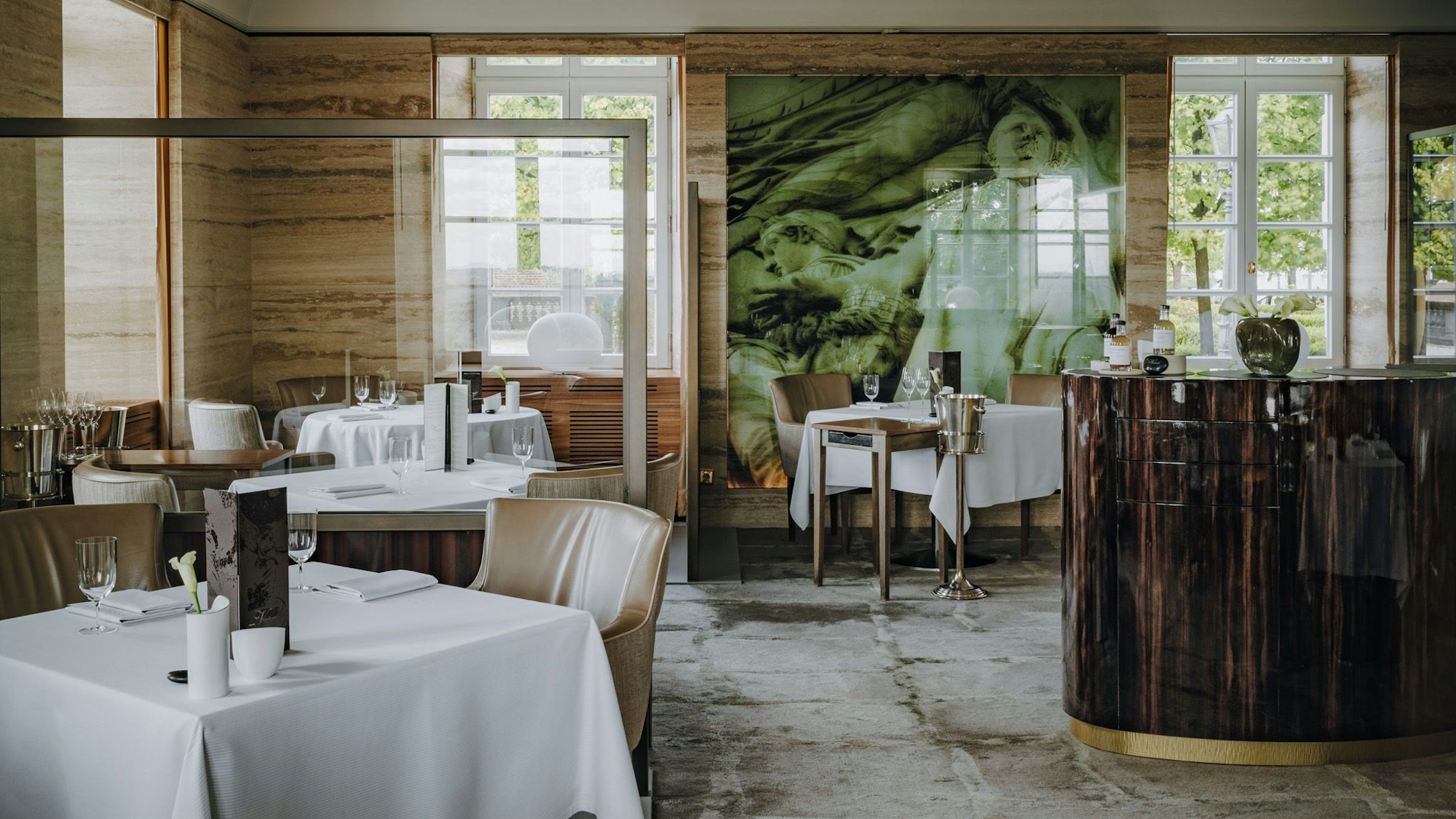 Ein Restaurant-Raum mit in Weiß gedeckten Tischen und Stühlen.