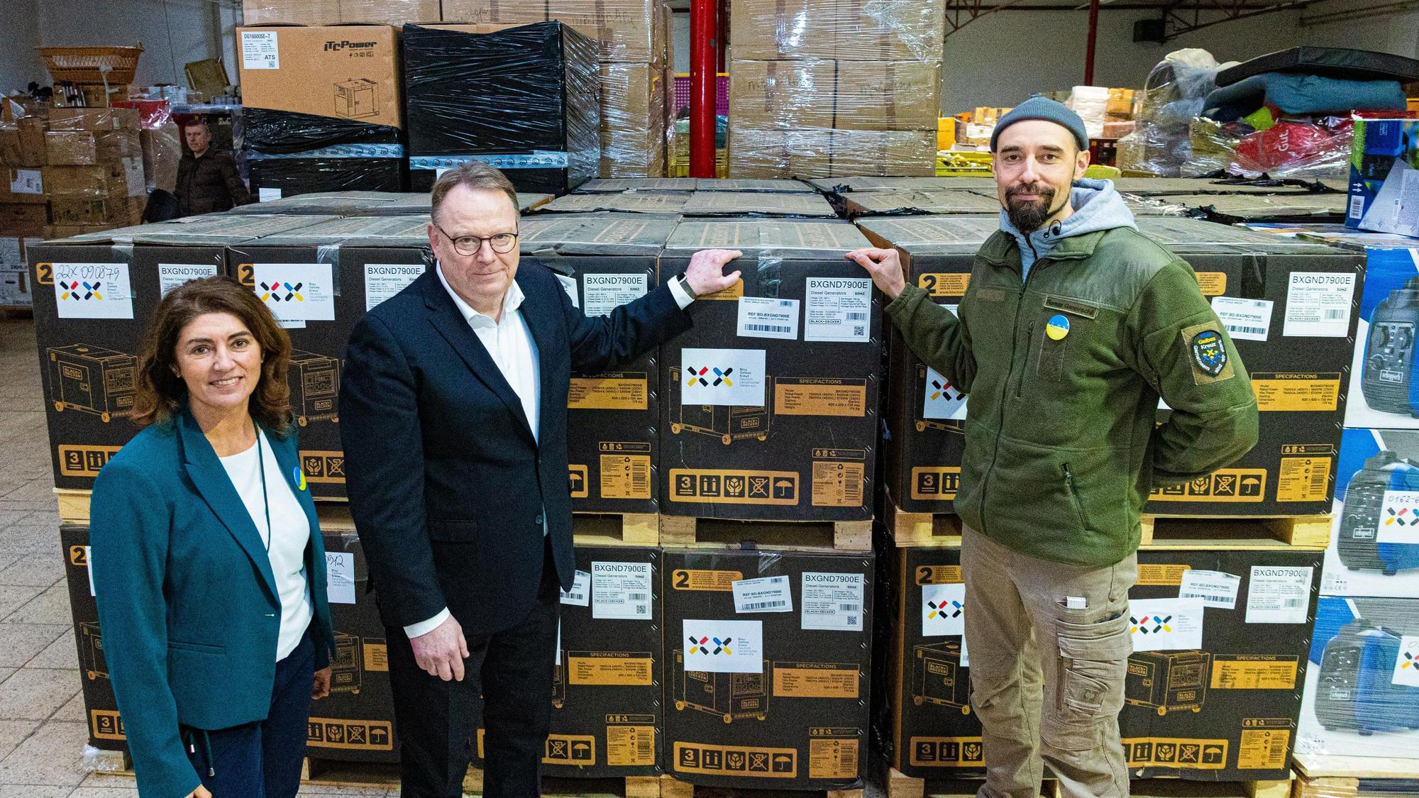 Über 14.000 Generatoren hat das Blau-Gelbe Kreuz (BGK) bereits in die Ukraine transportiert, im Lager des Vereins stehen weitere bereit. OB Torsten Burmester (Mitte) wurde von der Vorstandsvorsitzenden Linda Mai und dem Logistikleiter Roman Ganovscii durch die Halle geführt.
