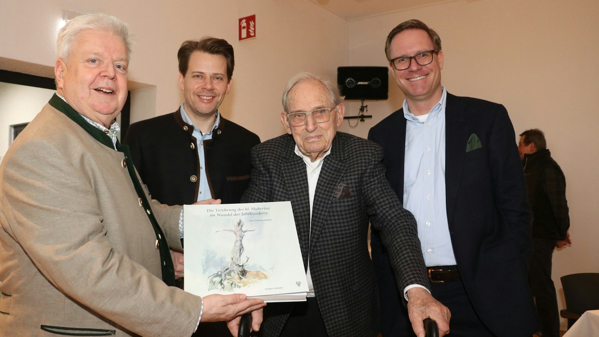 Von links stehen Manfred Heindl (Vorstand KJS) mit einer Neuauflage vom Heiligen Hubertus in der Hand, Arne von Boetticher (Landrat RBK), Dr. Günter Schlieker und Dr. Michel Metten nebeneinander.