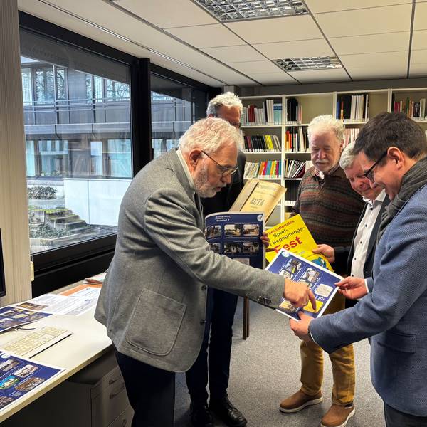 Werner Quadt (Arbeitskreis Stadtgeschichte und Fotogruppe) zeigt Max Leitterstorf (Bürgermeister) einen Teil der Fotoausstellung „Sankt Augustin früher und heute“.