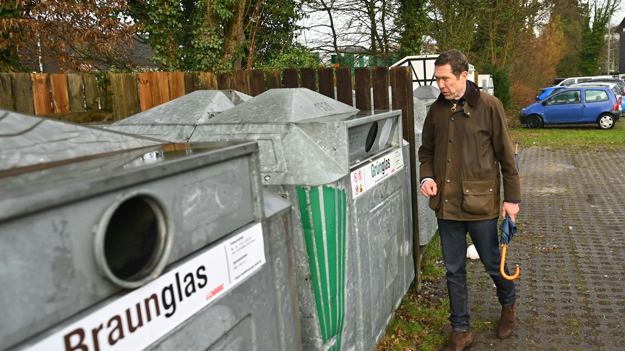 Das Bild zeigt den Gummersbacher Bürgermeister an einem Glascontainer.