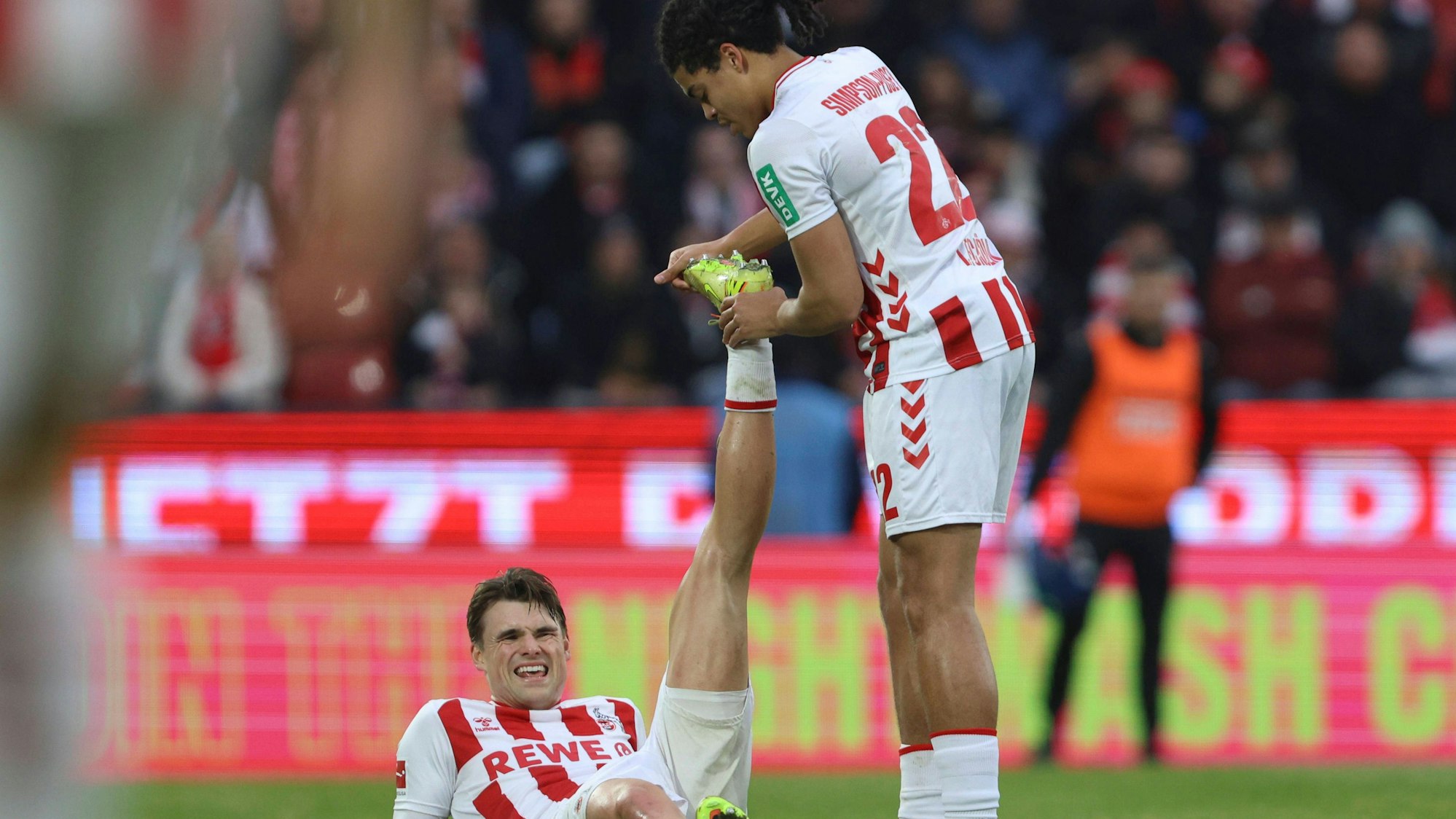 Joel Schmied vom 1. FC Köln liegt während der Partie gegen die TSG Hoffenheim verletzt am Boden. Jahmai Simpson-Pusey kümmert sich.