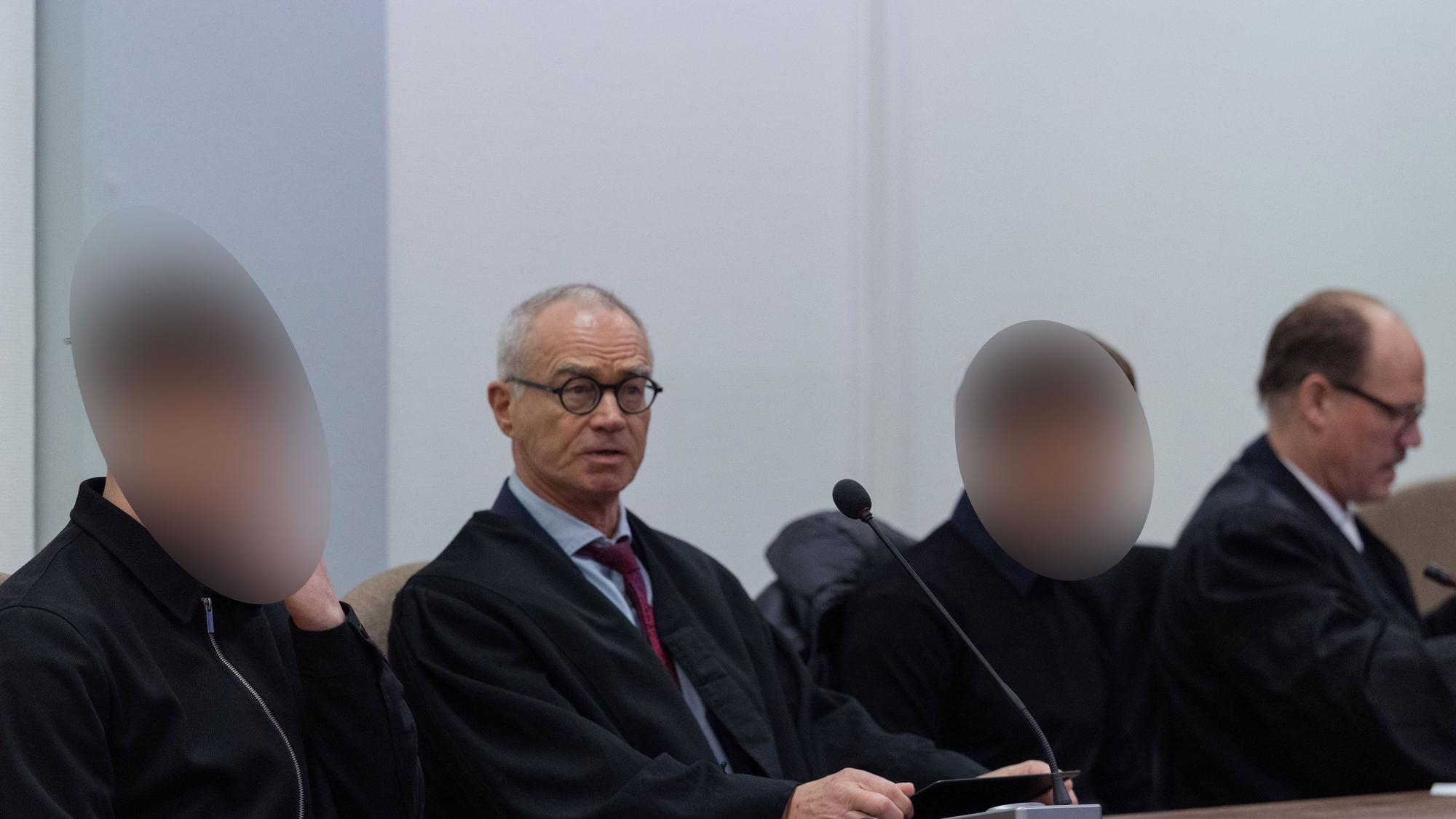 Die beiden Angeklagten sitzen im Landgericht Köln neben ihren Anwälten.