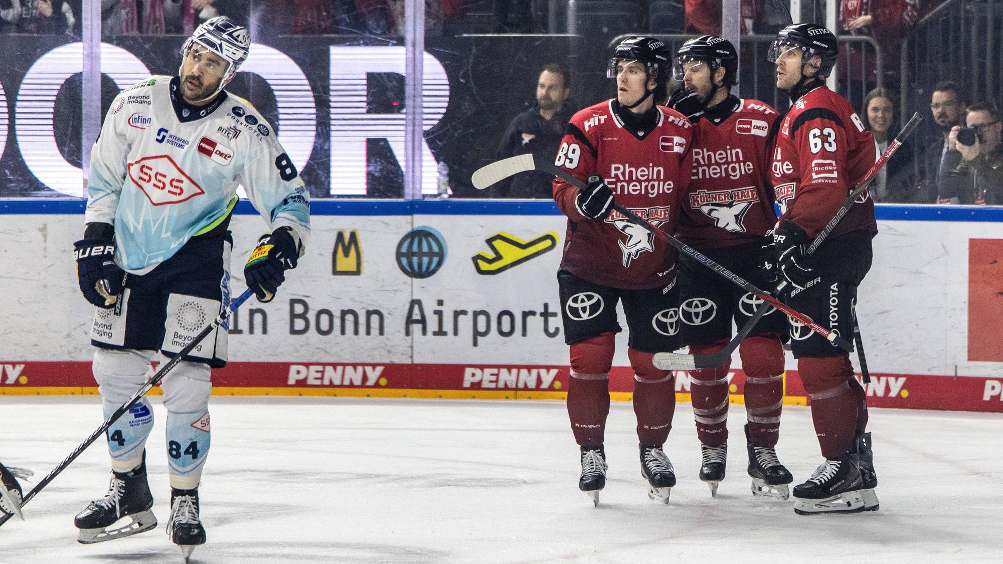 In die 2. Liga geschickt: Gregor MacLeod, Tanner Kero und Patrick Russel (r.) feiern das 1:0 der Haie, während Austin Ortega (l.) enttäuscht abdreht.