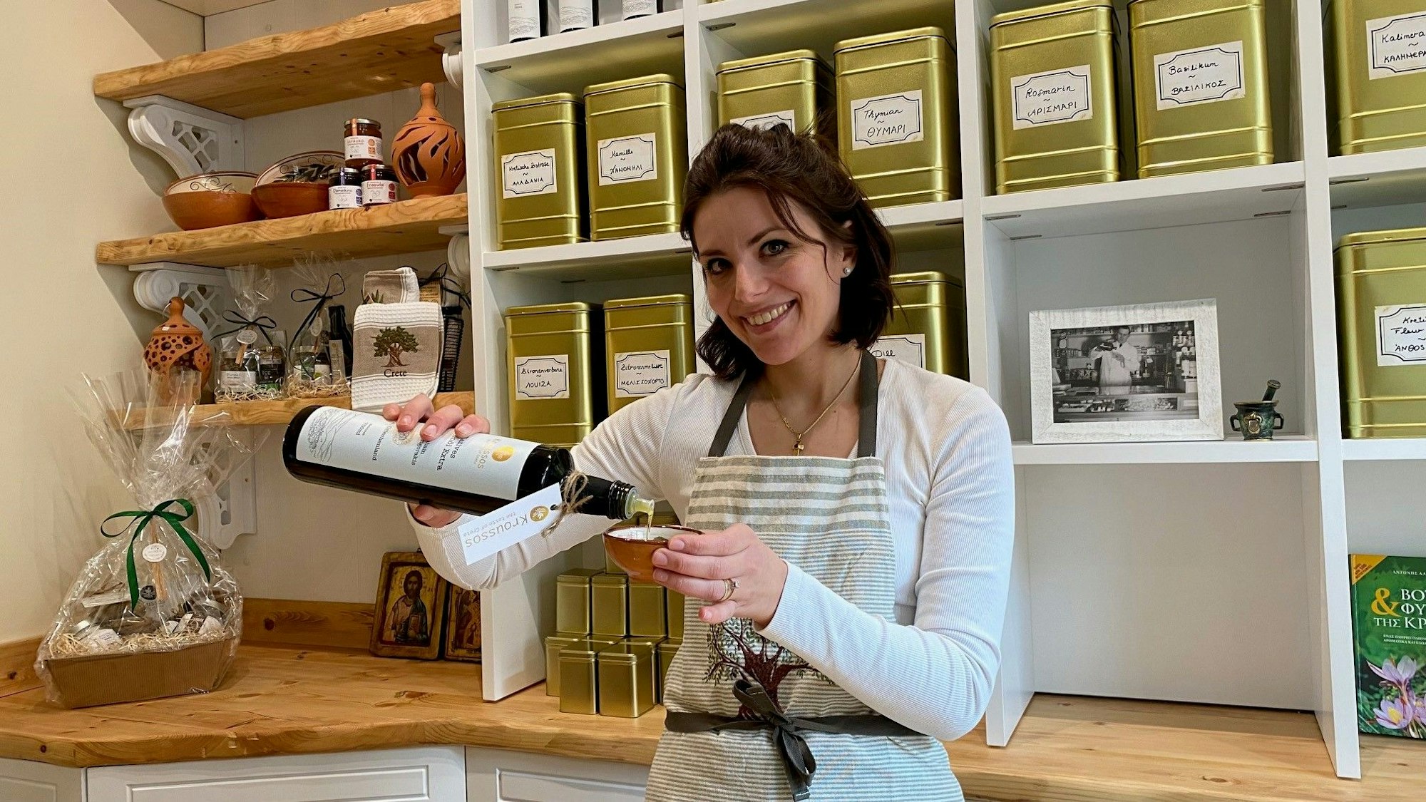 Zu sehen ist Michaela Grigorakis, die Olivenöl in ein Schälchen füllt.