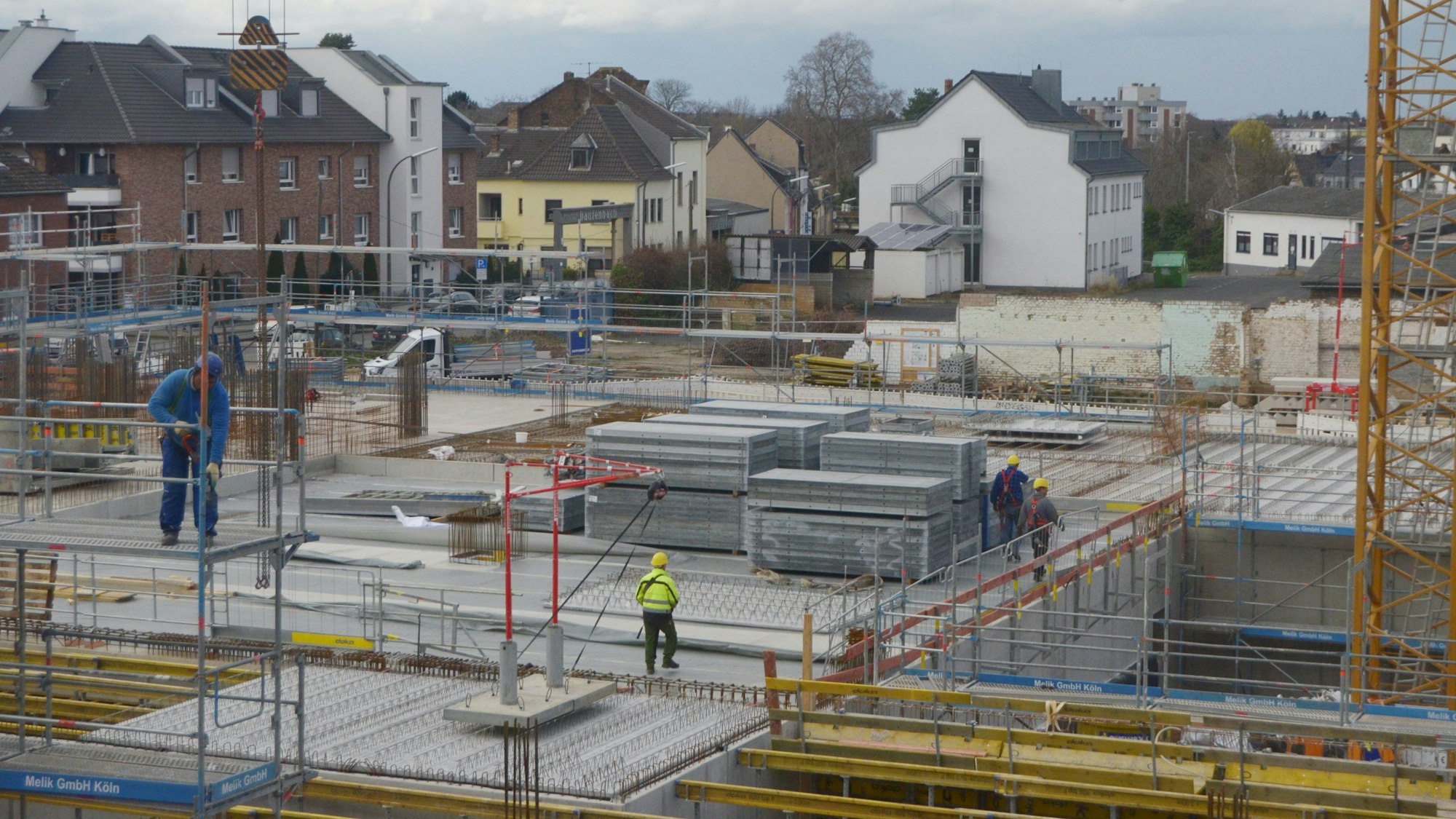 Auf der Baustelle eines großen Gebäudes sind Arbeiter unterwegs.