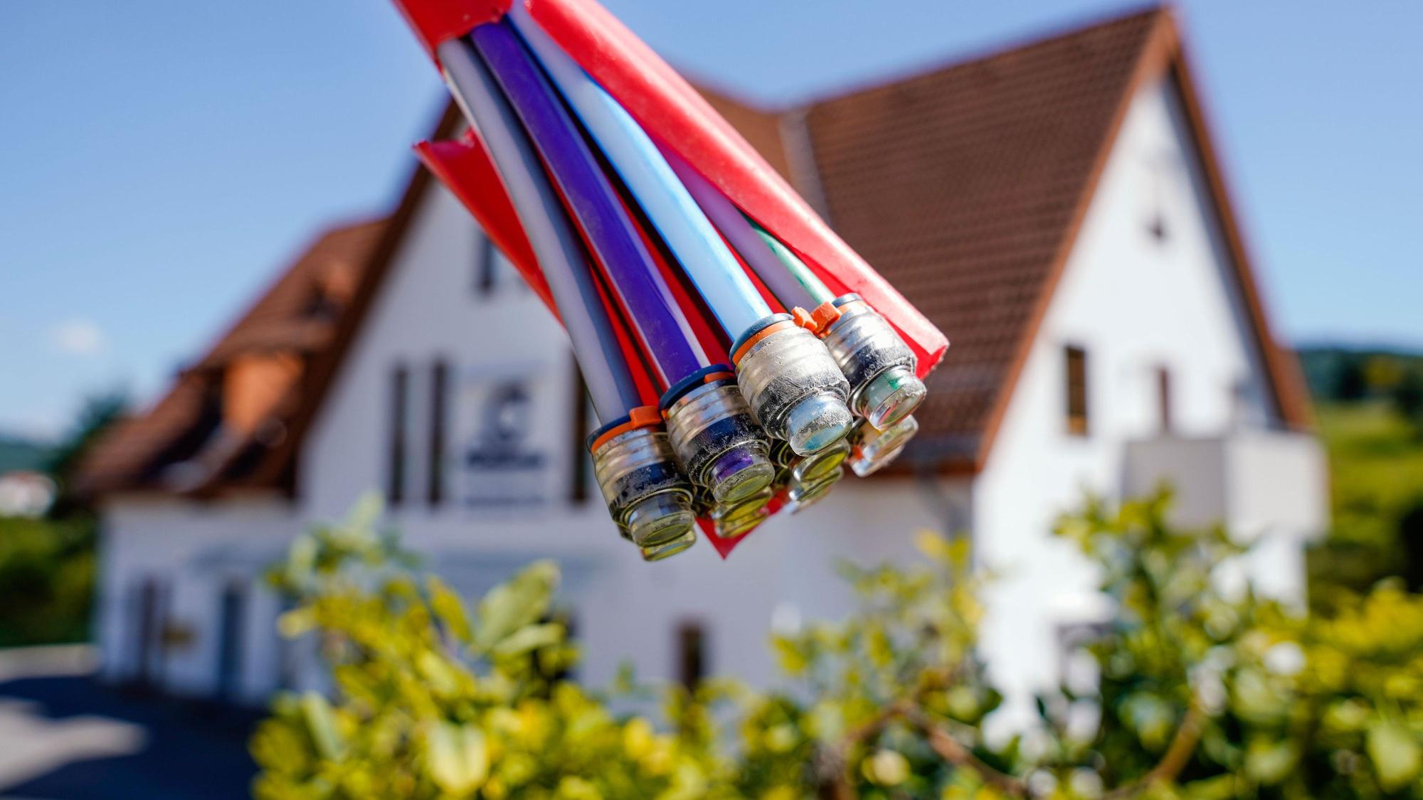 Zu sehen ist ein Symbolbild für Glasfaser mit einem Haus im Hintergrund.
