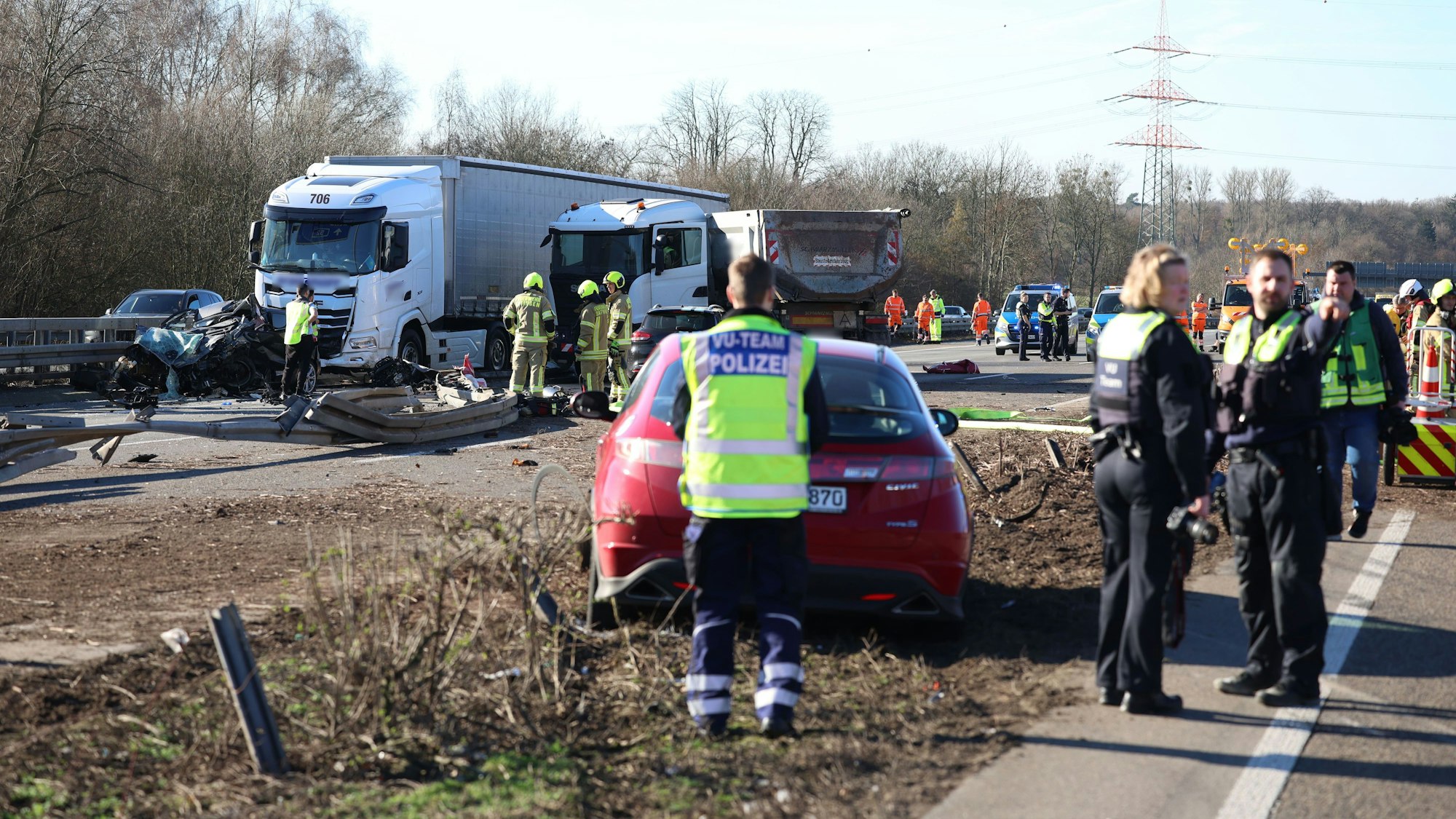 Nach einem Unfall, an dem LKW beteiligt waren, stehen Helfer und Polizei am Mittwoch (25. Februar) auf der Autobahn A3 bei Ratingen.