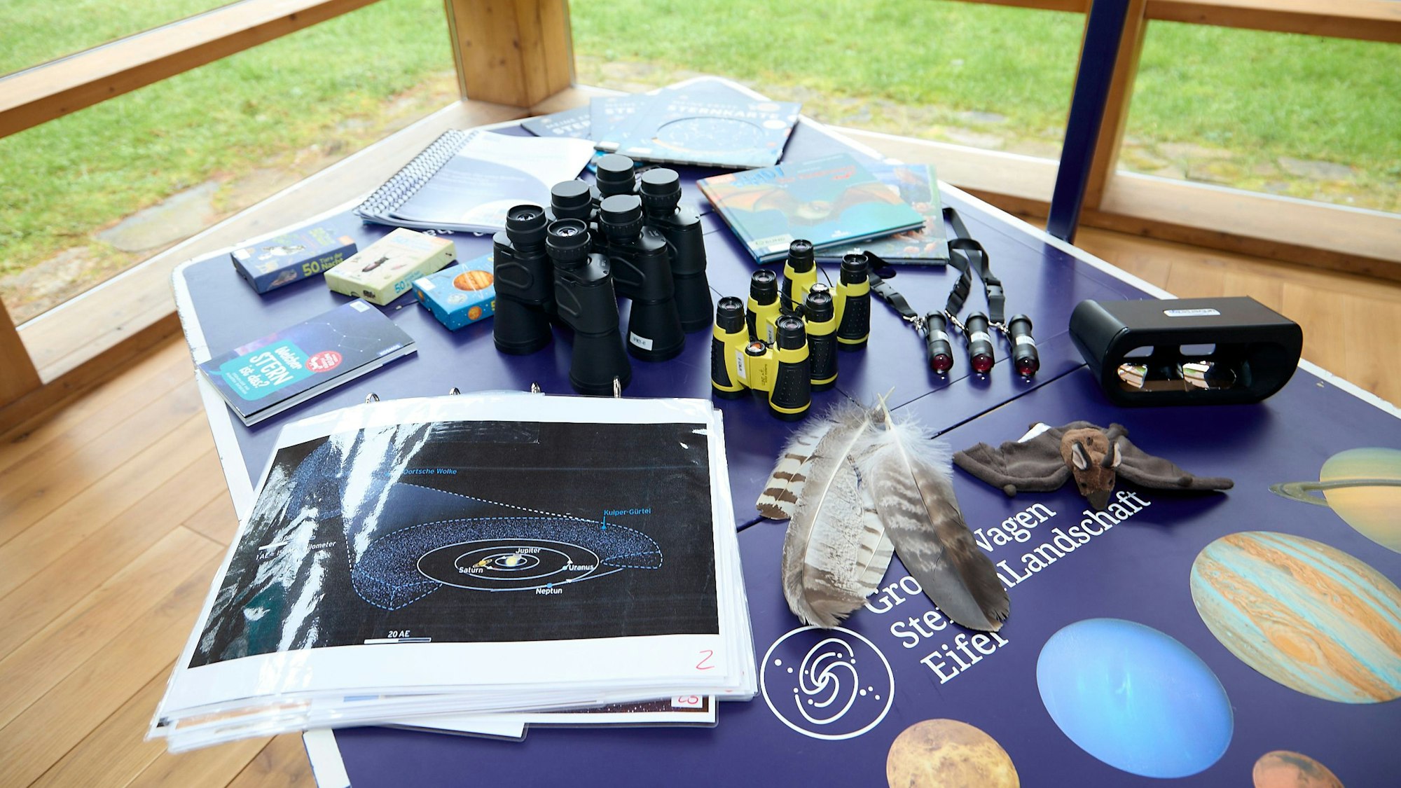 Auf dem Tisch liegen unterschiediche Arbeitsmaterialien, die die Sternen-Guides nutzen, etwa Ferngläser.