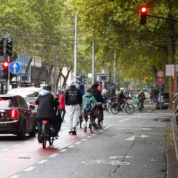 Radfahrende auf den Kölner Ringen. Dort ist eine ehemalige Autospur für Radfahrer freigegeben, ohne bauliche Abtrennung vom Autoverkehr.
