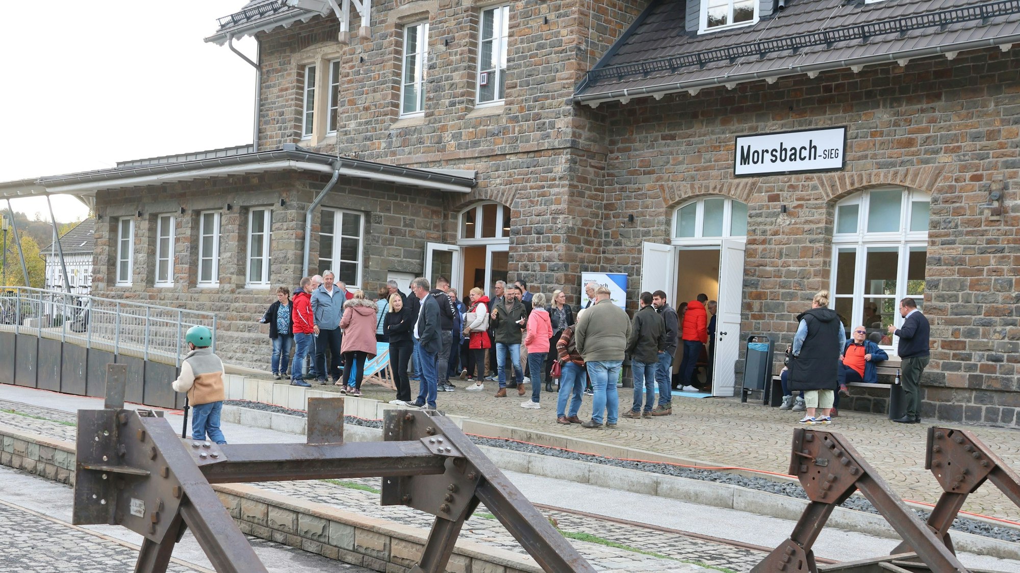 Das Foto zeigt das Freizeitgelände Kulturbahnhof in Morsbach am Tag seiner Einweihung. Im Vordergrund zu sehen sind alte Gleisanlagen mit historischem Bahnsteig hinter dem Kulturbahnhof.