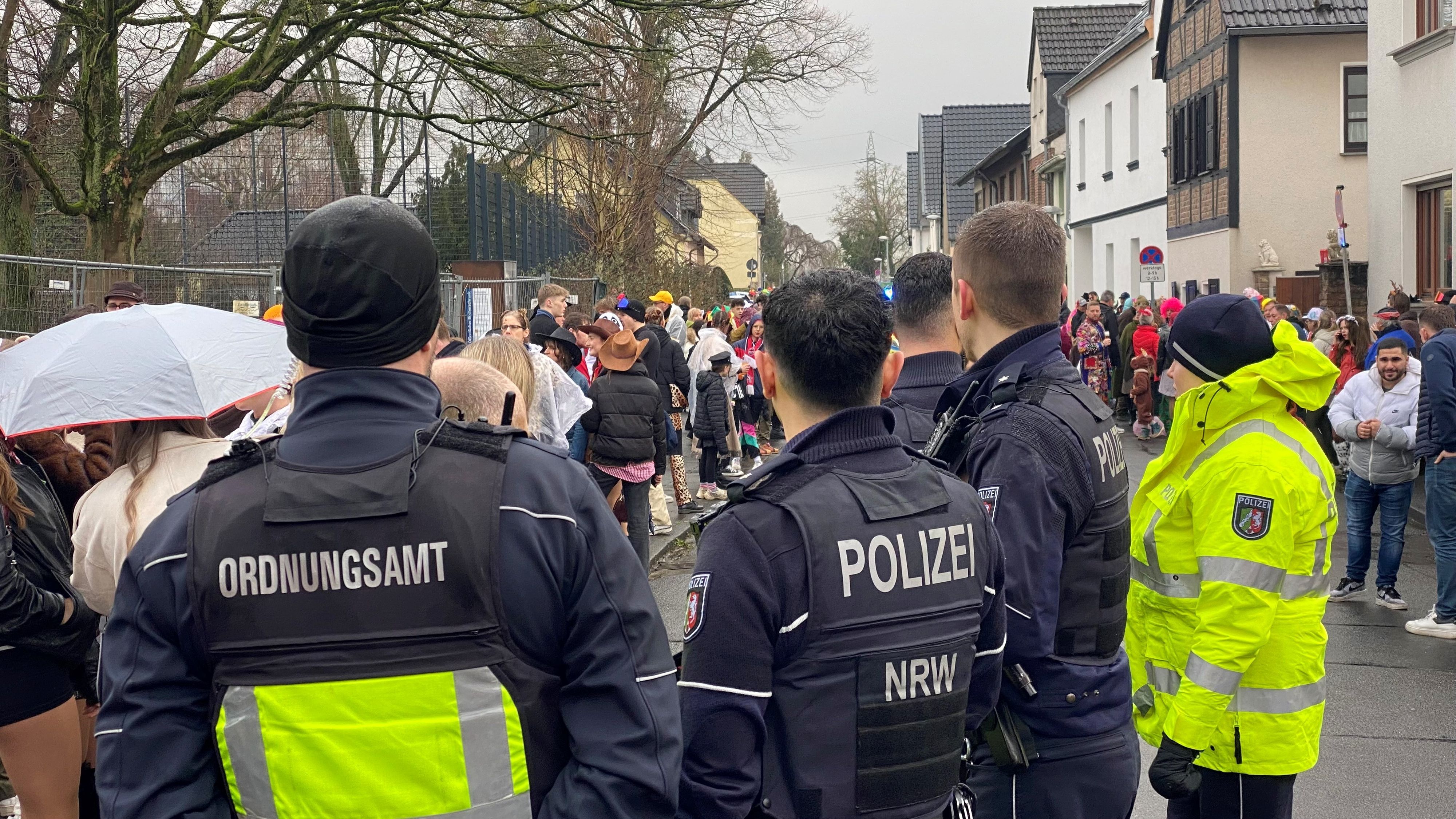 Zu sehen sind Einsatzkräfte von Ordnungsdienst und Polizei bei einem Karnevalszug.