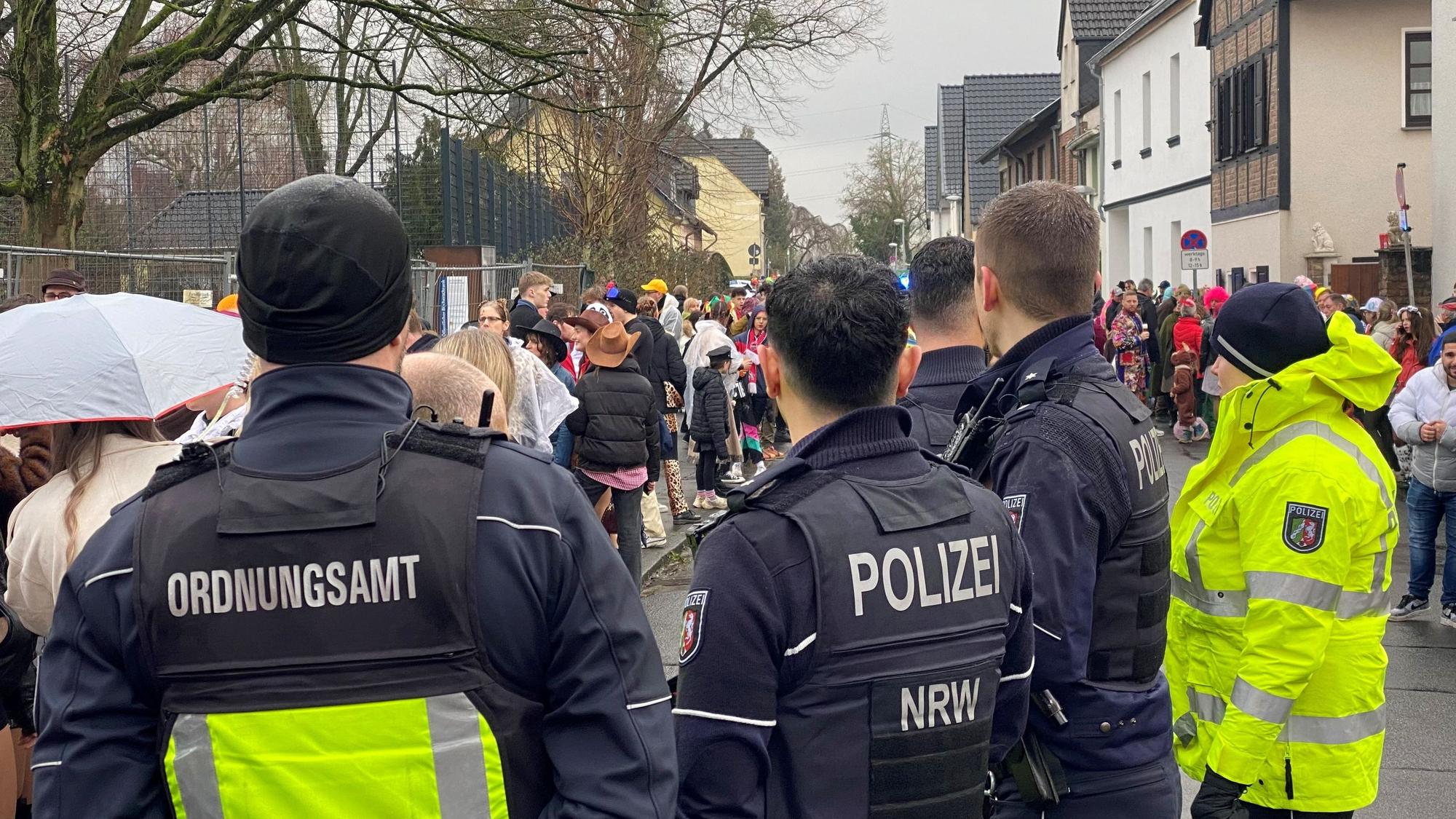 Zu sehen sind Einsatzkräfte von Ordnungsdienst und Polizei bei einem Karnevalszug.