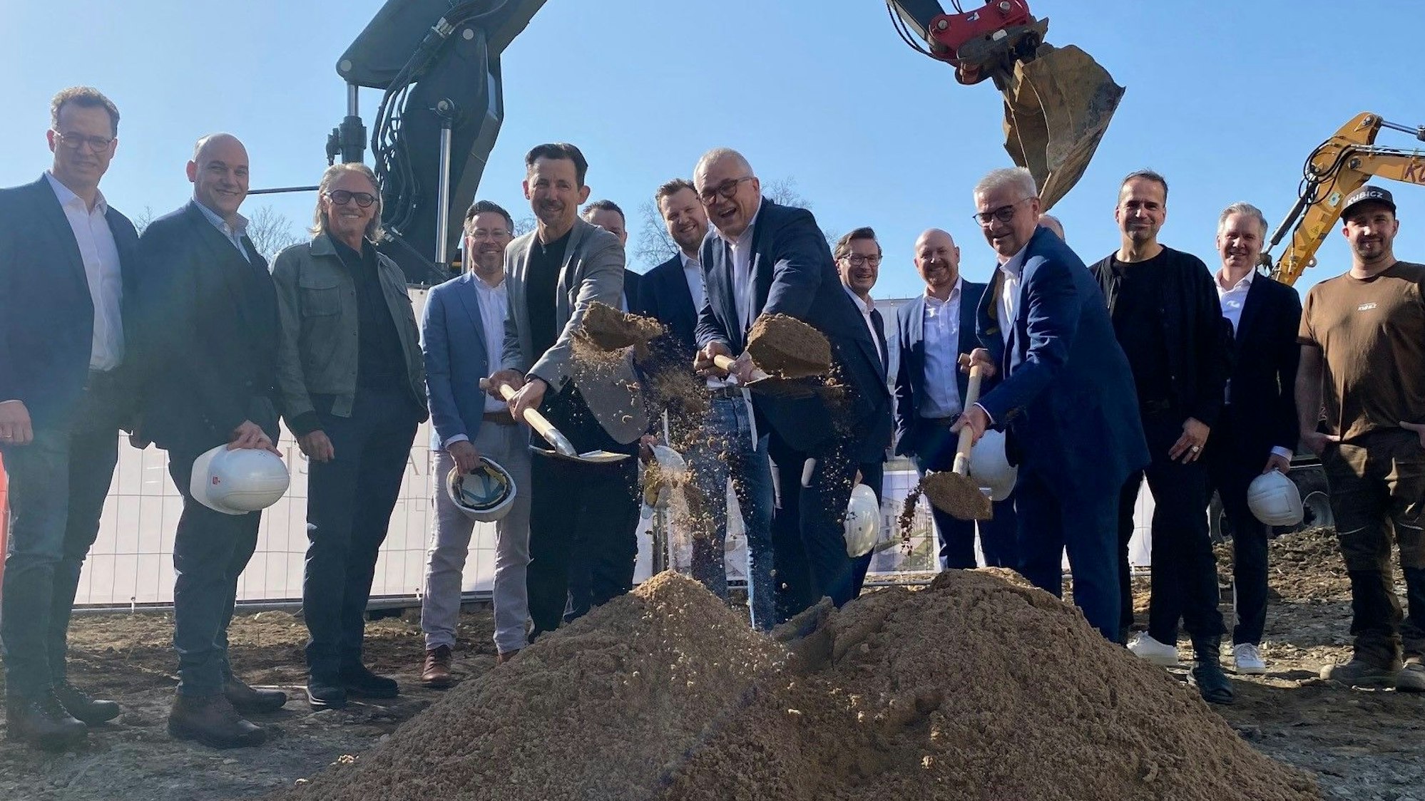 Zu sehen sind mehrere Männer beim Spatenstich.