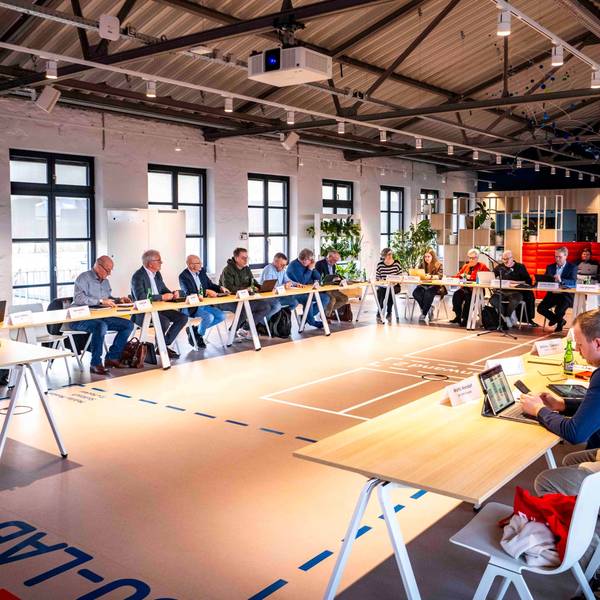 Das Bild zeigt einen Moment der Ausschusssitzung in der Ideenfabrik. Zahlreiche Politikerinnen und Politiker sitzen an Tischen.