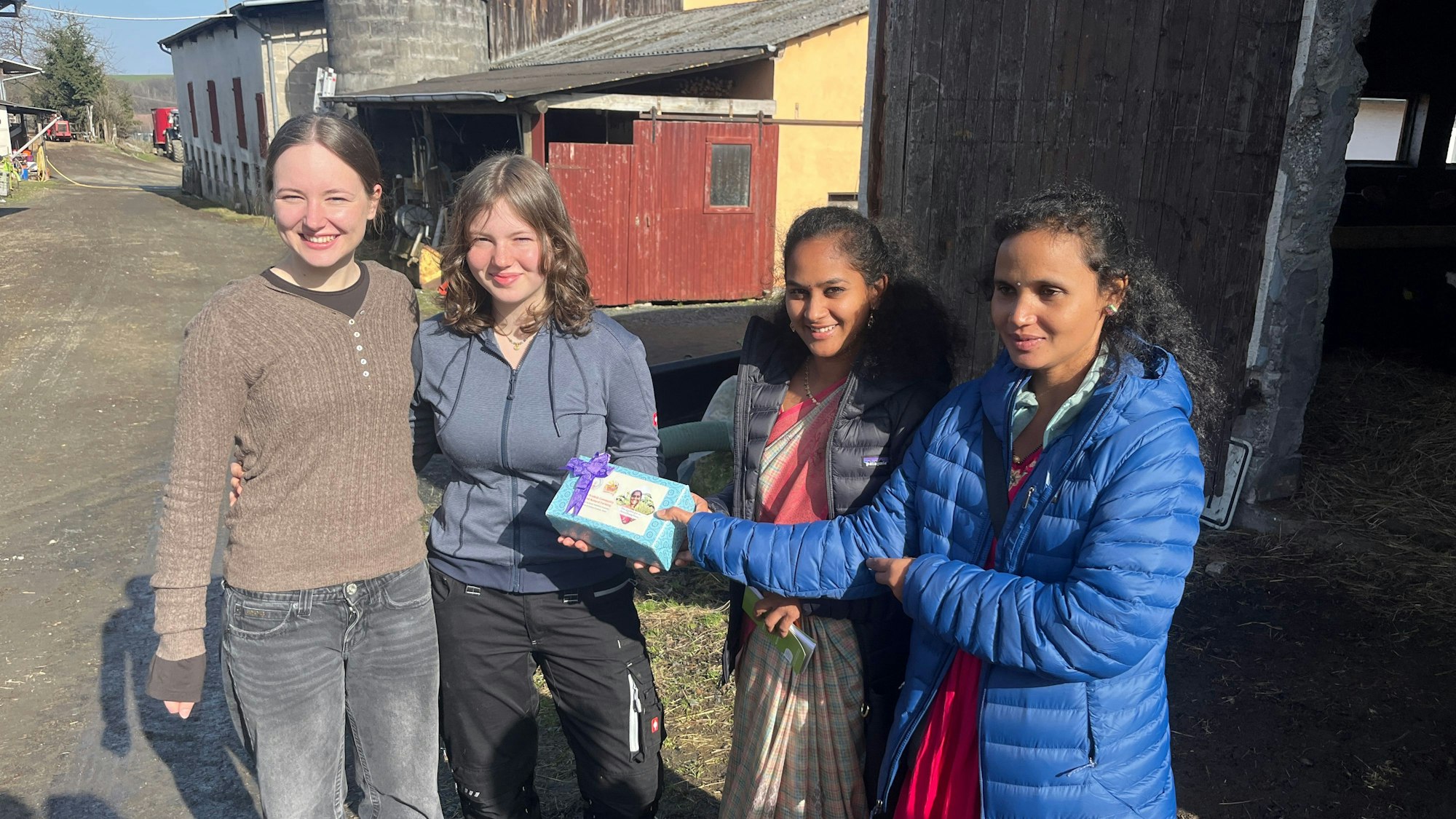 Zwei indische Bäuerinnen besuchten vor der internationalen Konferenz von „Weltacker International“ den Hanfer Hof. Paula Fehling (2.v.l.) führte sie mit ihrer Schwester Luisa durch den Betrieb.