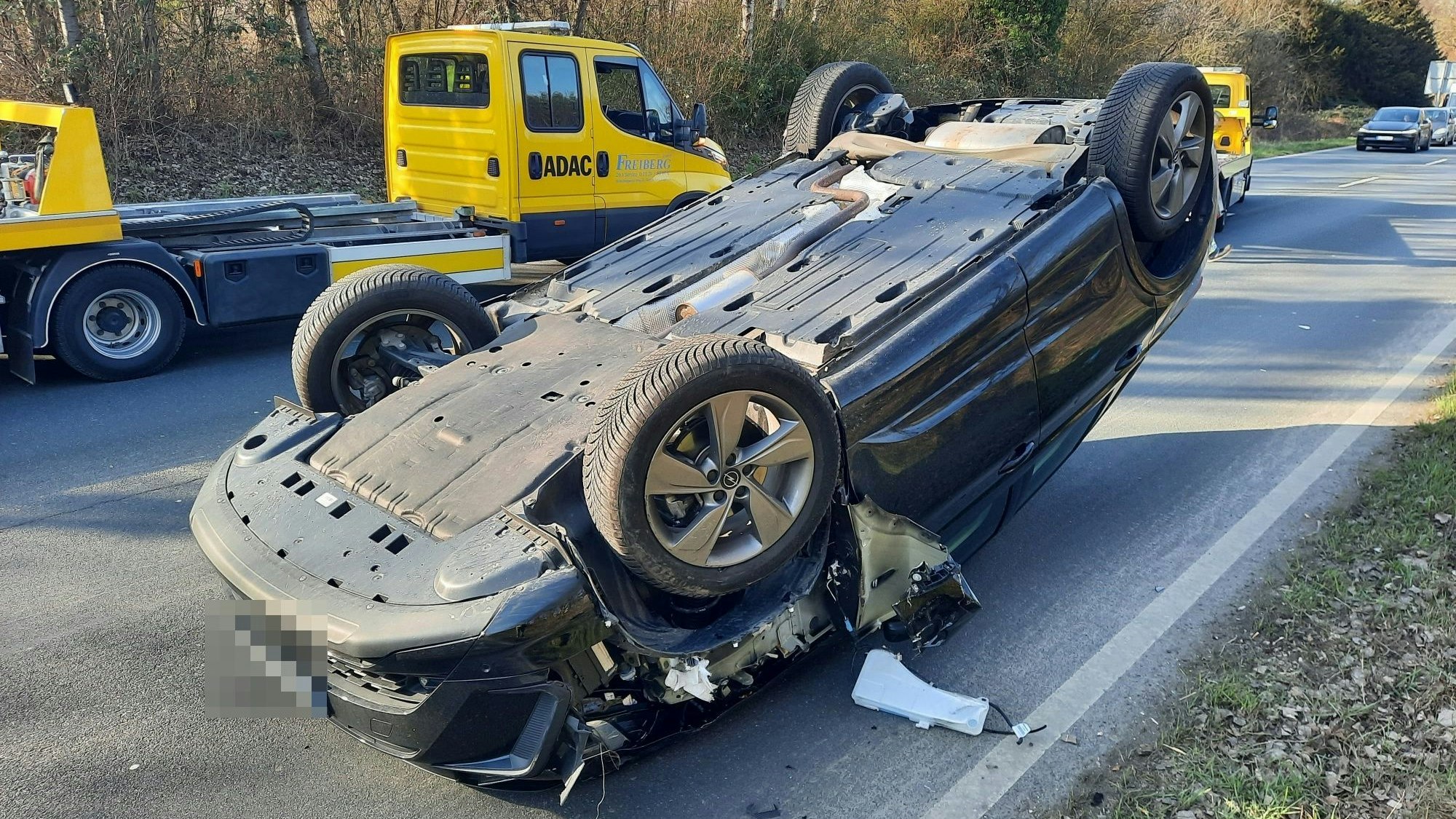 Ein blaues Auto liegt auf dem Dach