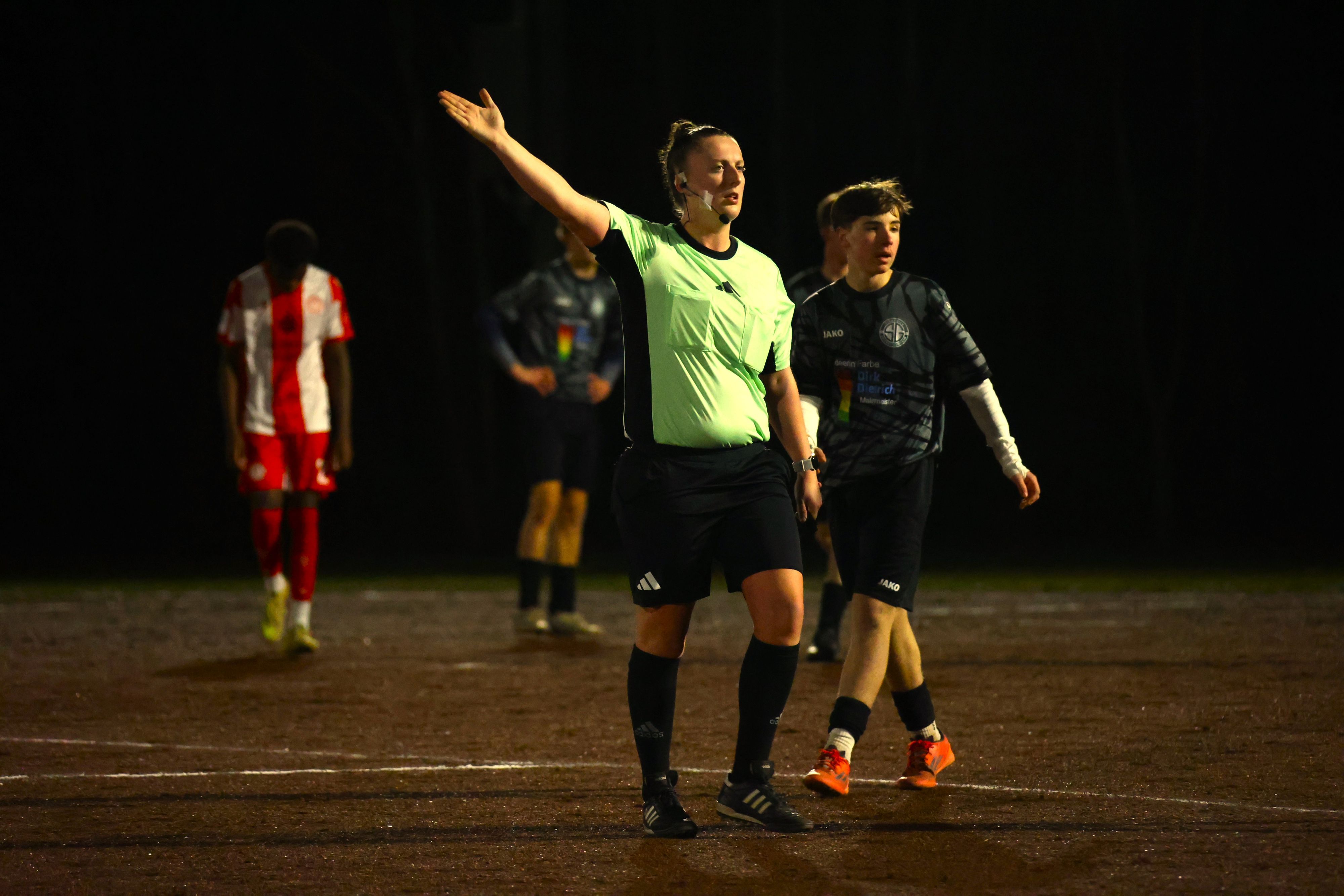 Schiedsrichterin Lisa Reinecke zeigt mit einer Geste eine Entscheidung an.