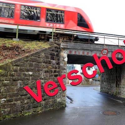 Über ein Bild der Bahnüberführung Lüghauser Straße in Rösrath-Hoffnungsthal prangt der Schriftzug „Verschoben“.