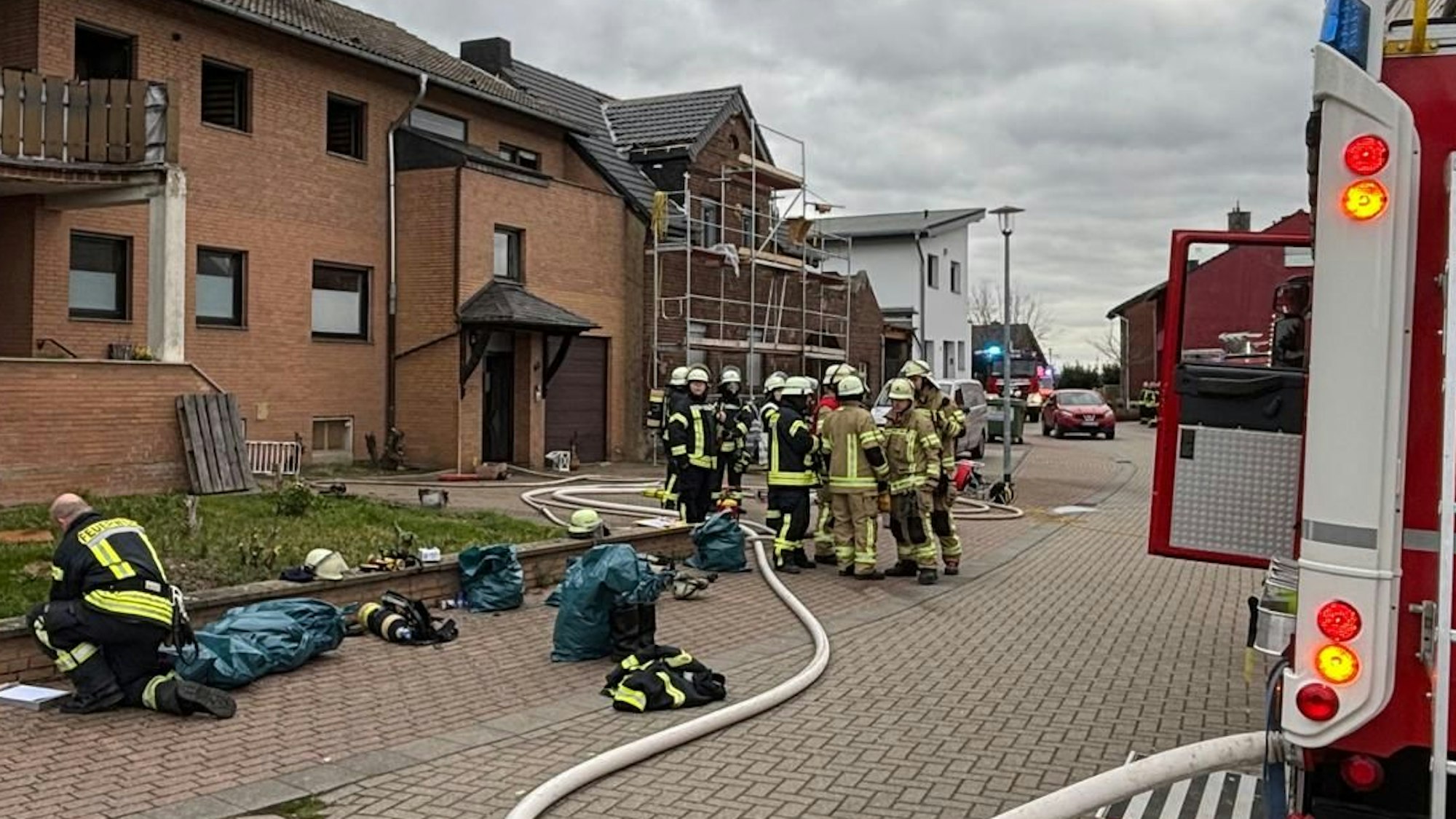 Das Bild zeigt Feuerwehrleute vor einem Wohnhaus.