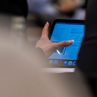 Das Bild zeigt ein Mitglied des Kreistags vor seinem Ipad. Dort ist die Tagesordnung der Sitzung hinterlegt.