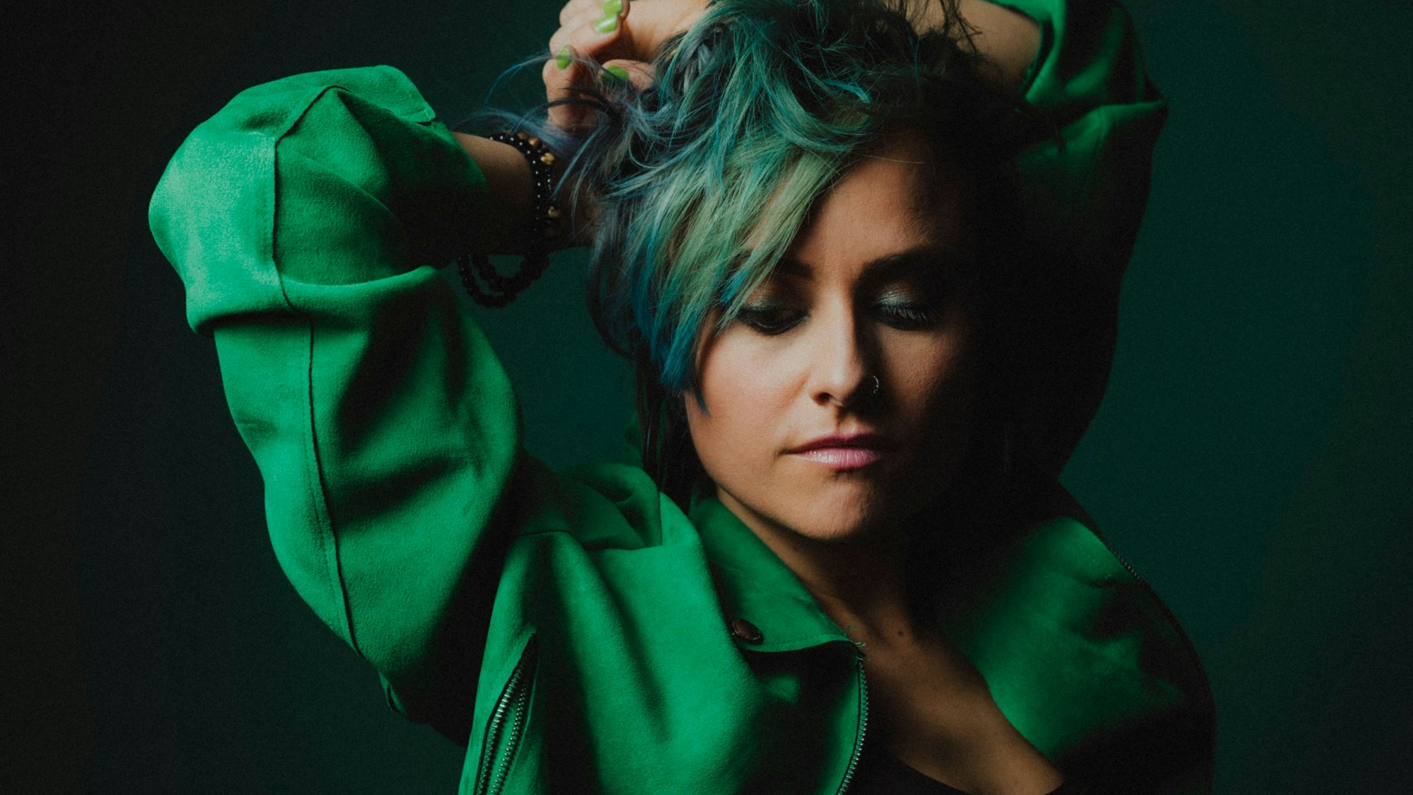 Eine Frau mit grüner Bluse und grünen Haaren.