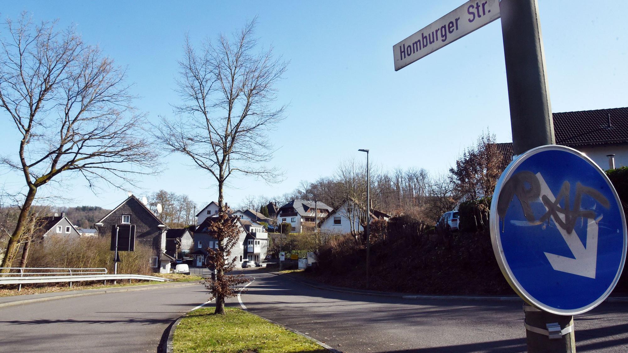 Einen Straßenschild und eine leere Fahrbahn.