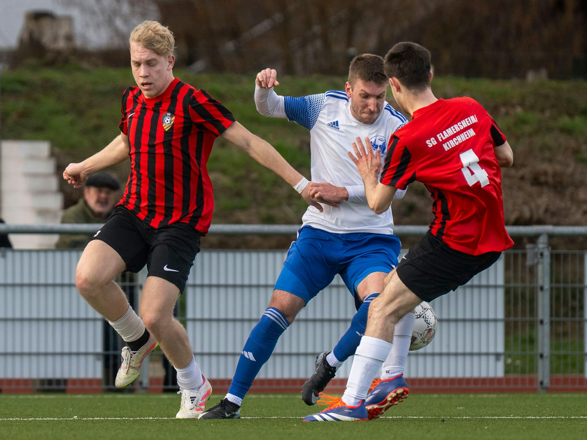Weilerswists Björn Büscher nimmt es gleich mit zwei Gegenspielern der SG FlaKi auf.