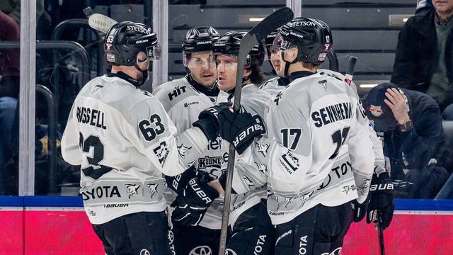 Die Kölner Haie feiern ihren Siegtorschützen Gregor MacLeod (Mitte).
