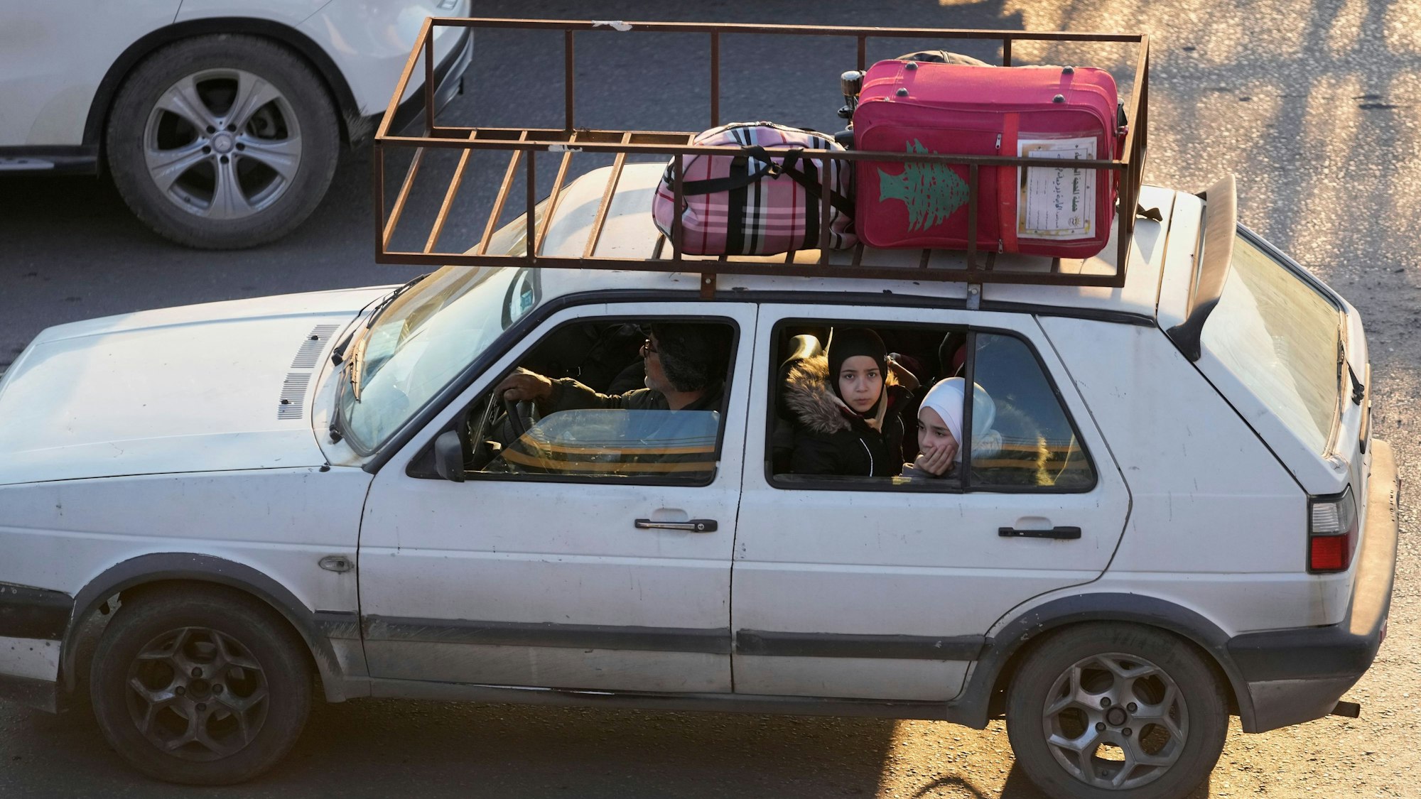 Eine Familie, die vor den israelischen Angriffen im Südlibanon flieht, sitzt in einem Auto an einer Autobahnverbindung nach Beirut.