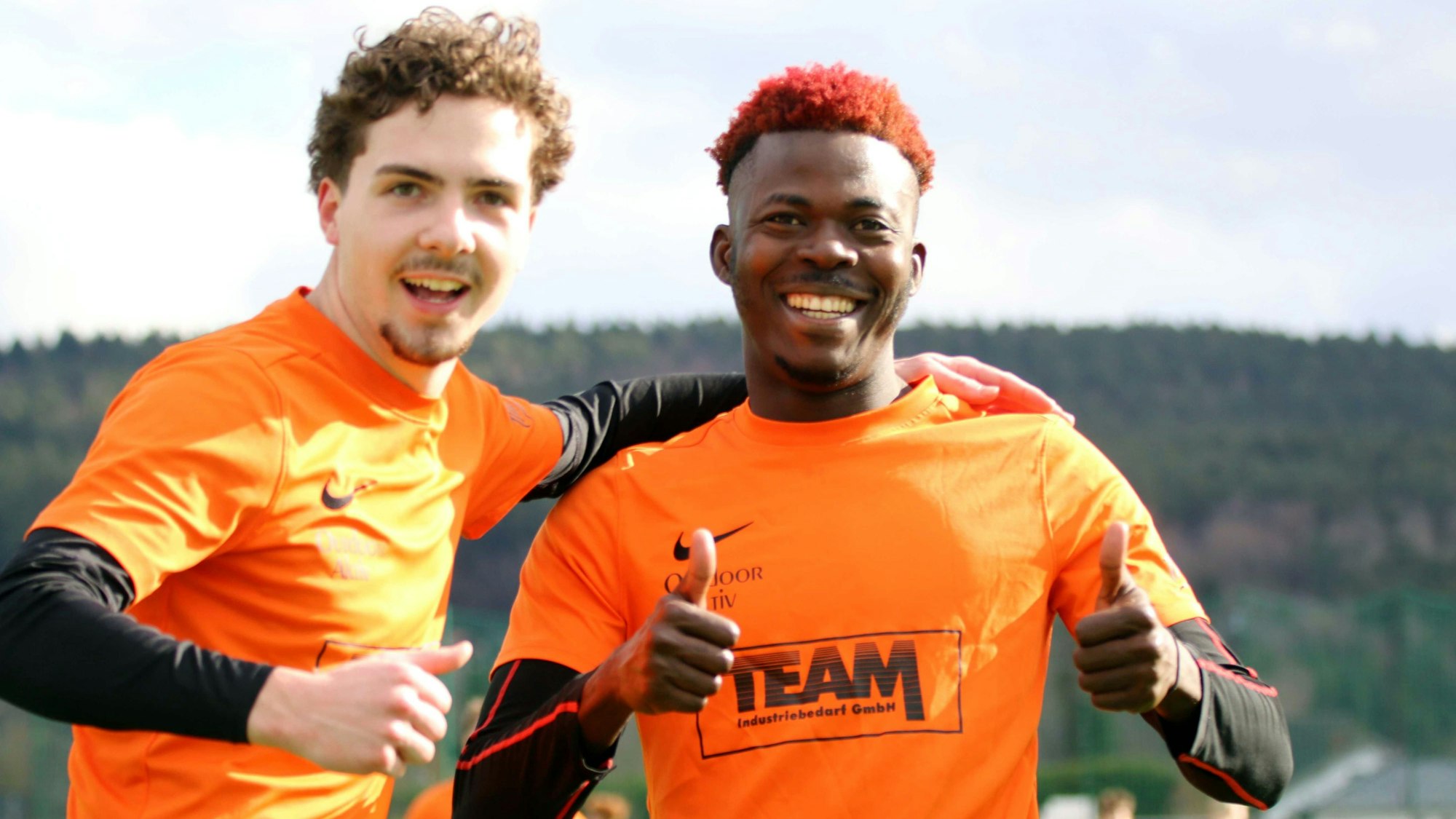 Zwei Fußballer jubeln mit erhobenen Daumen in Richtung der Kamera.