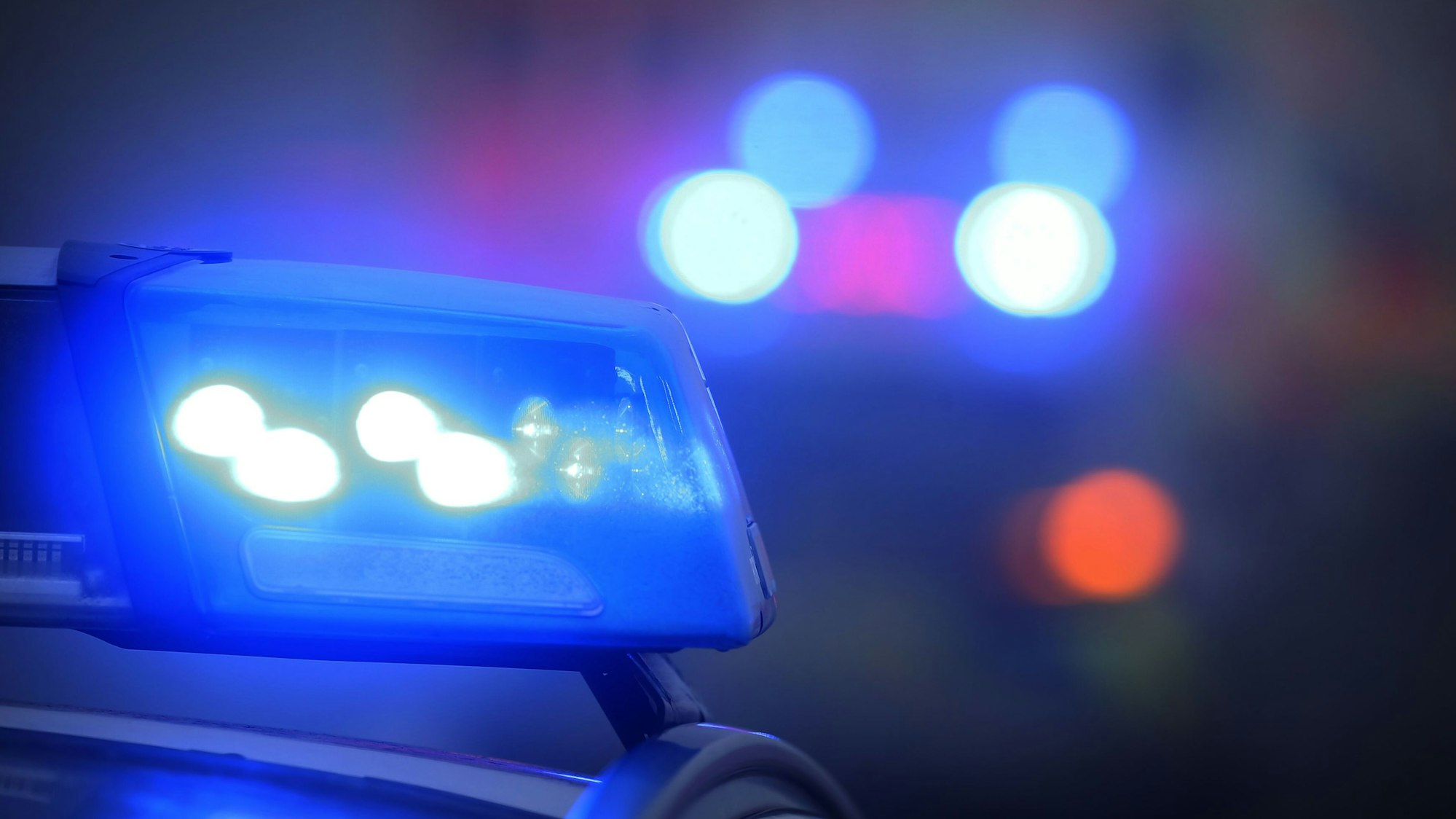 Ein Polizeiauto mit eingeschaltetem Blaulicht.