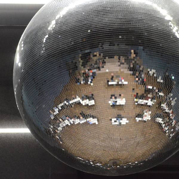 Tische und Stühle einer Gremiensitzung spiegeln sich in einer Discokugel.
