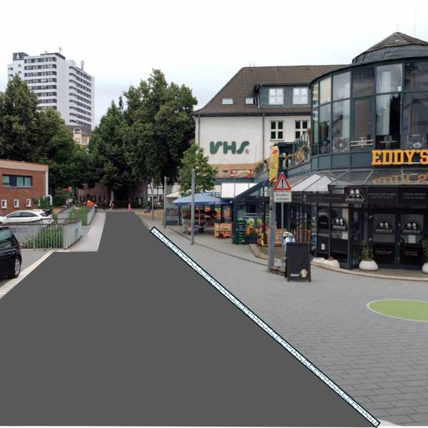 eine Fußgängerzone, auf der linken Seite ist das Pflaster durch Asphalt ersetzt