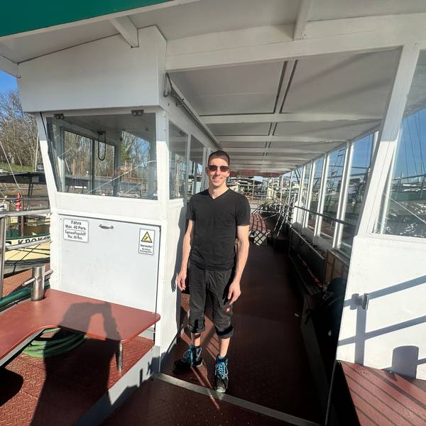 Ein junger Mann steht auf einem Boot.