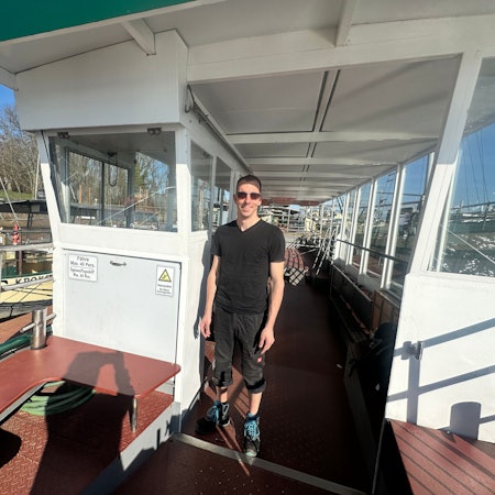 Ein junger Mann steht auf einem Boot.