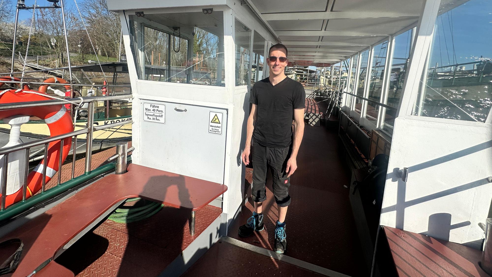 Ein junger Mann steht auf einem Boot.