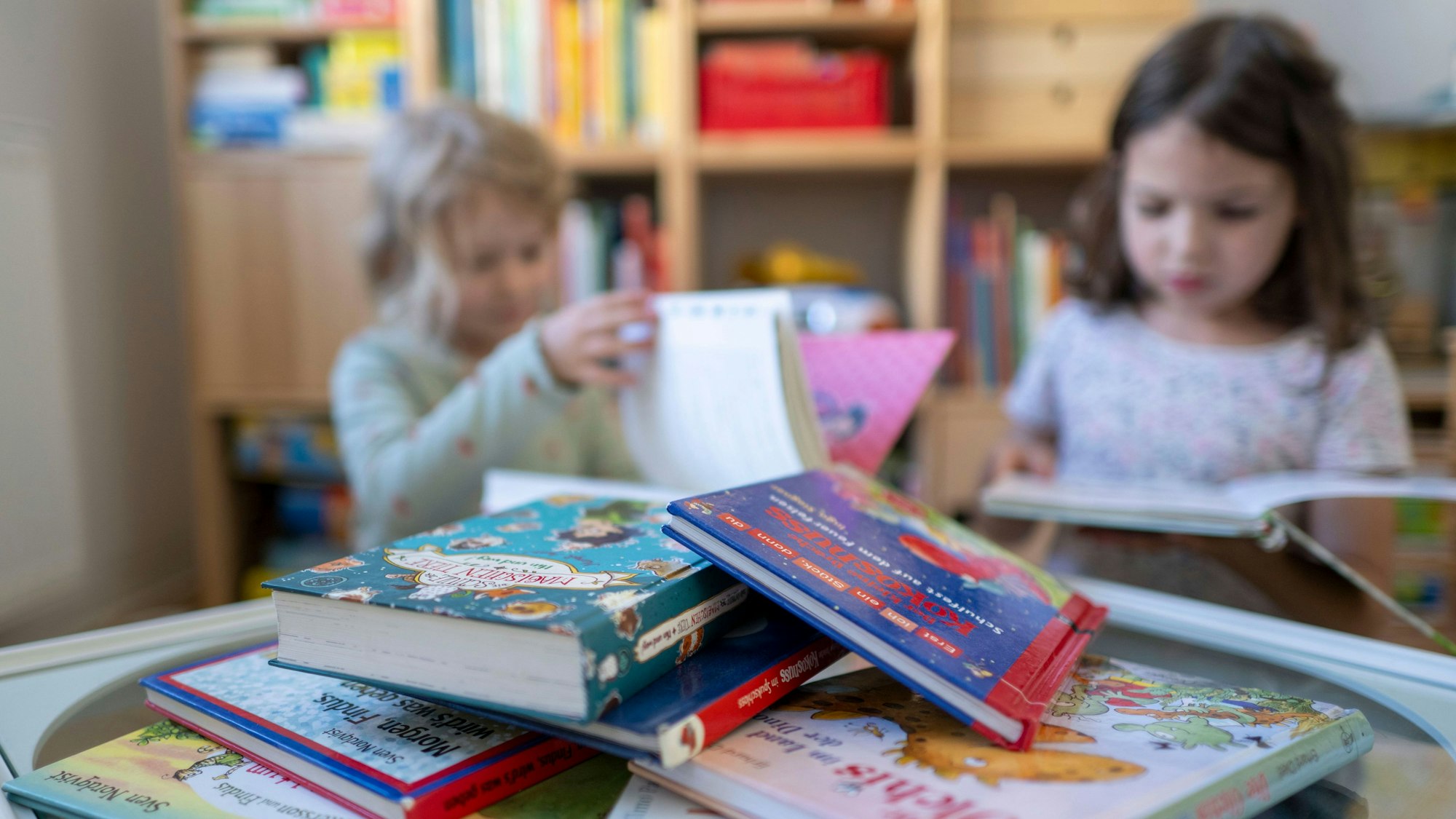 Kinder blättern in einem Kinderzimmer in Leipzig in Kinderbüchern.