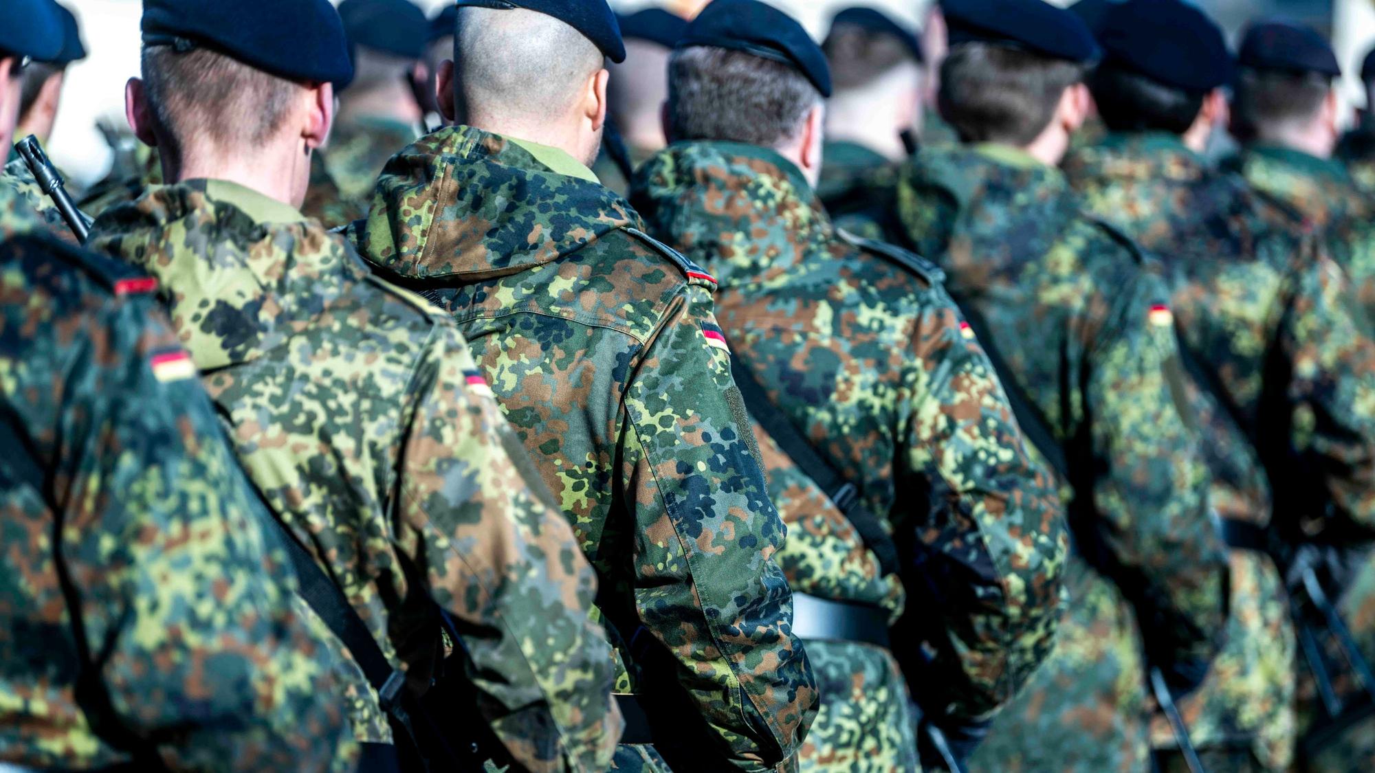 Eine Gruppe Soldaten marschiert hintereinander.
