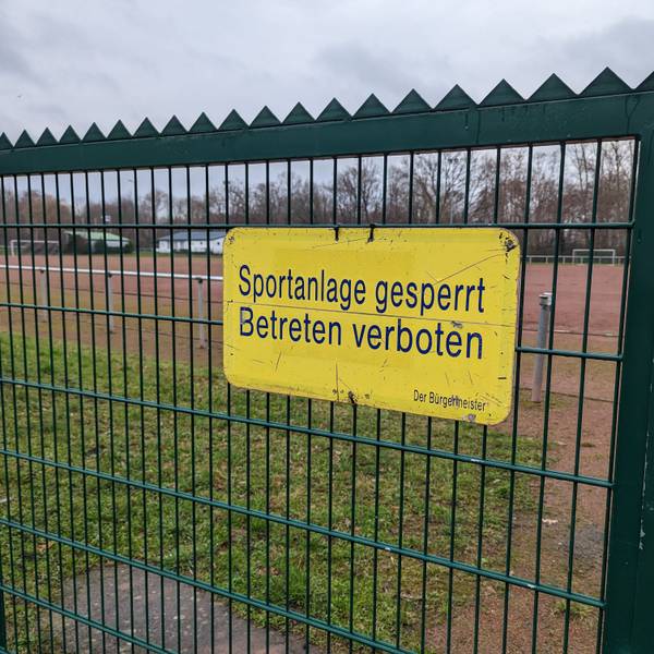 Das Foto zeigt das Hinweisschild „Sportanlage gesperrt“ am Tor des Tennenplatzes in Kendenich.